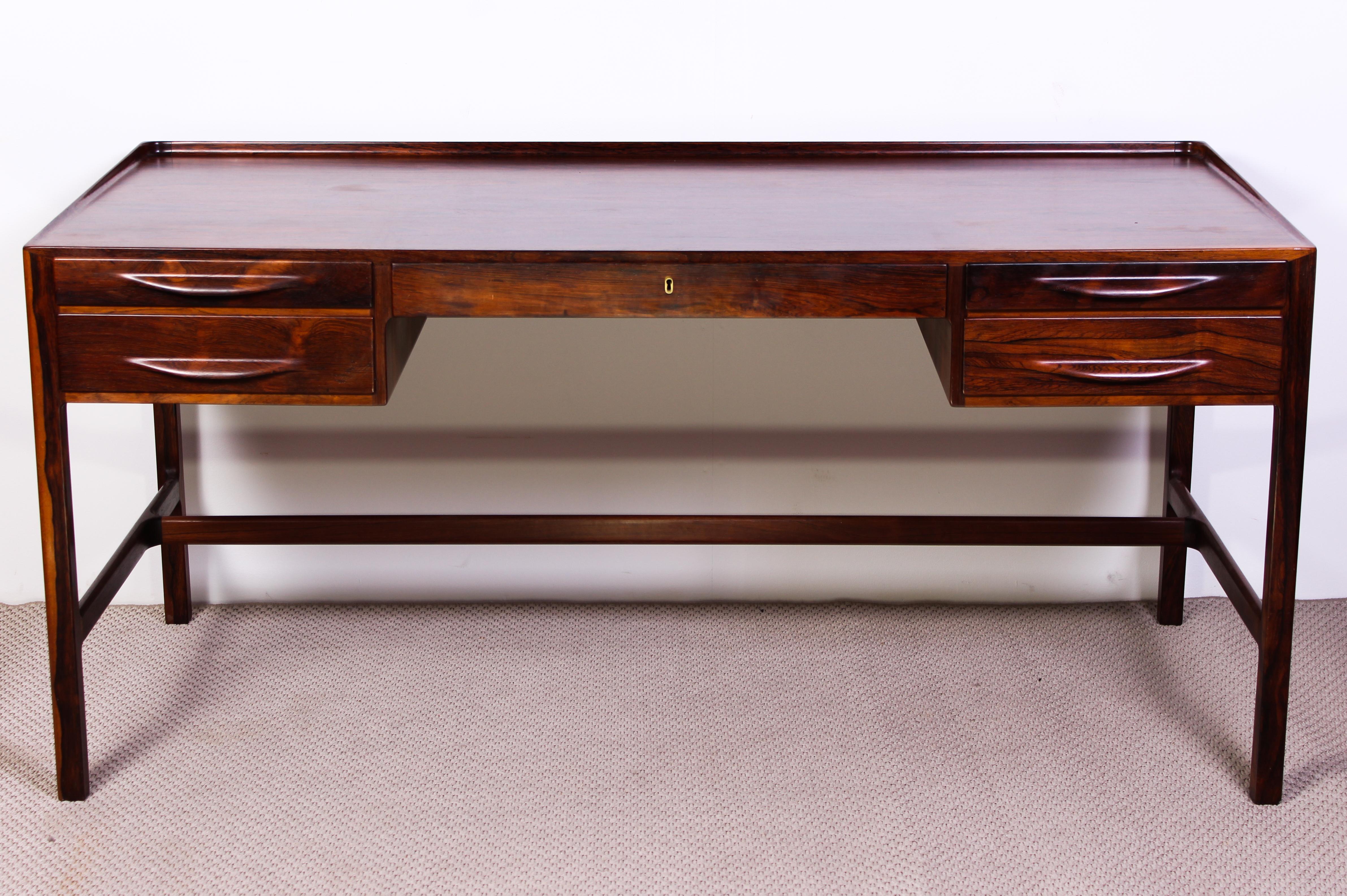 A very rare rosewood desk designed by Danish designer Kurt Østervig for Jason Møbler. The desk is made out of beautifully grained rosewood and has several nice details such as raised edge around the top and sculptured handles. The design looks great