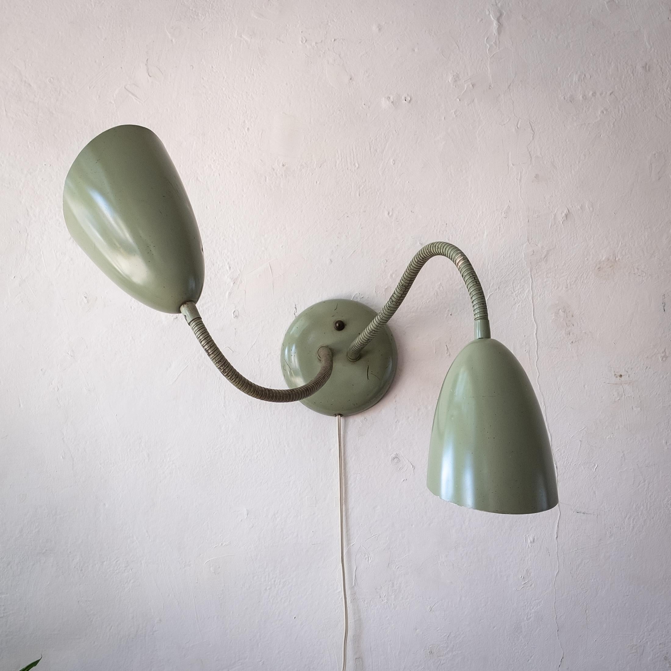 Mid century wall-mount double bullet cone lamp with fully adjustable goosenecks. Can also be used as a desk lamp. Kurt Versen lamps were selected for MoMA Good Design exhibitions and often selected for use in Case Study houses. A classic and