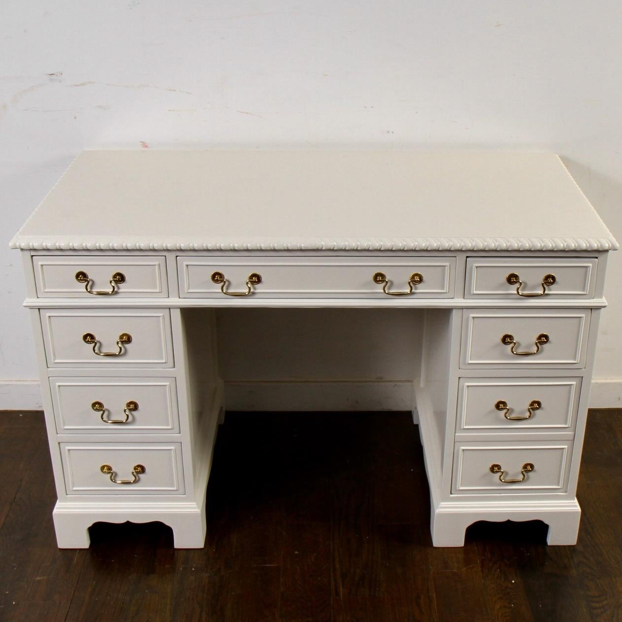 Great size desk for your home office. Originally mahogany, it's been re-invented in white dove lacquer. The middle drawer is stamped by American Table Company, “Taylor Made” Furniture, Jamestown, N.Y. The American Table Co. made fine furniture from