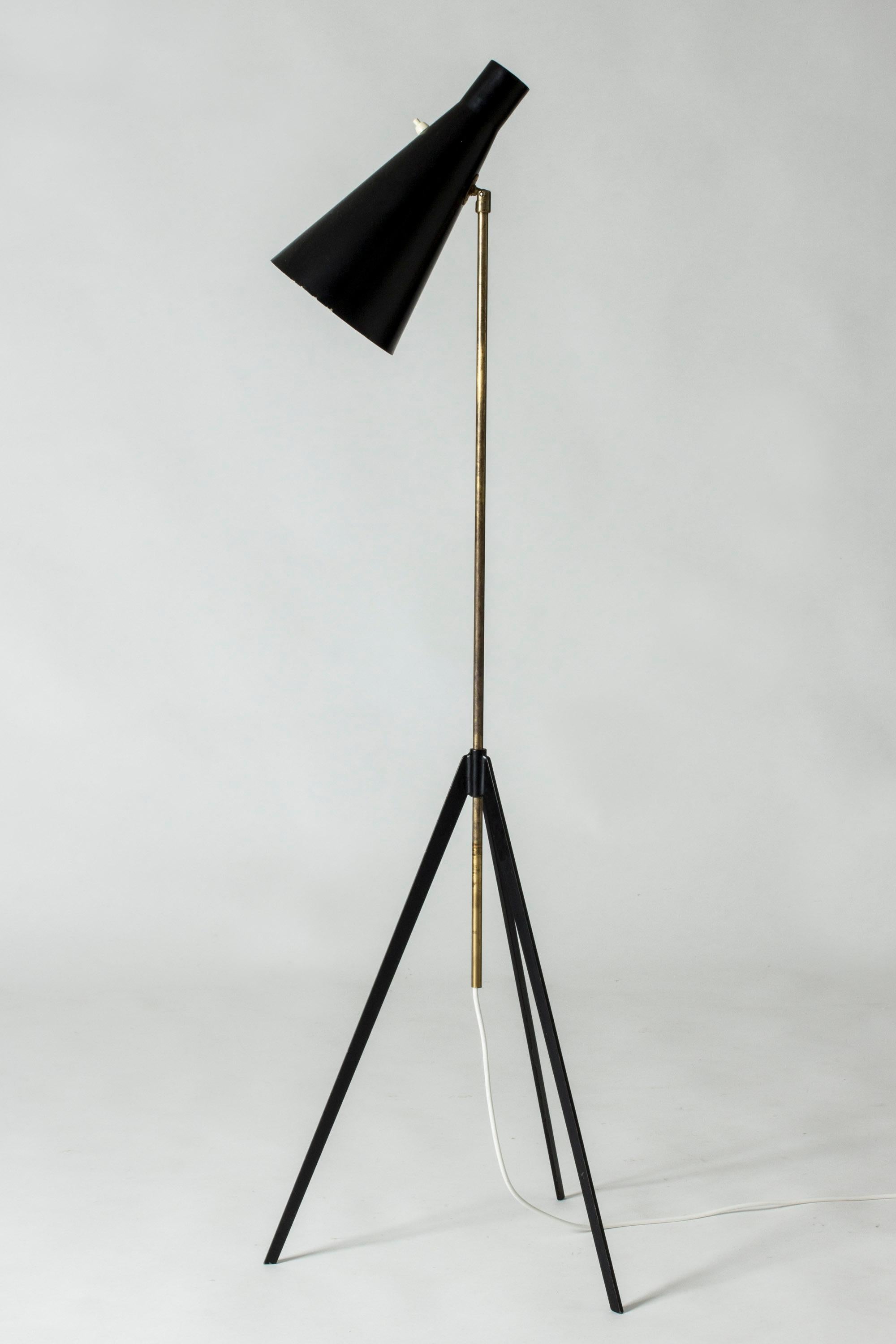 Cool brass and black lacquered metal floor lamp by Alf Svensson. Minimalistic, distinct design with a sharp-cut tripod base.