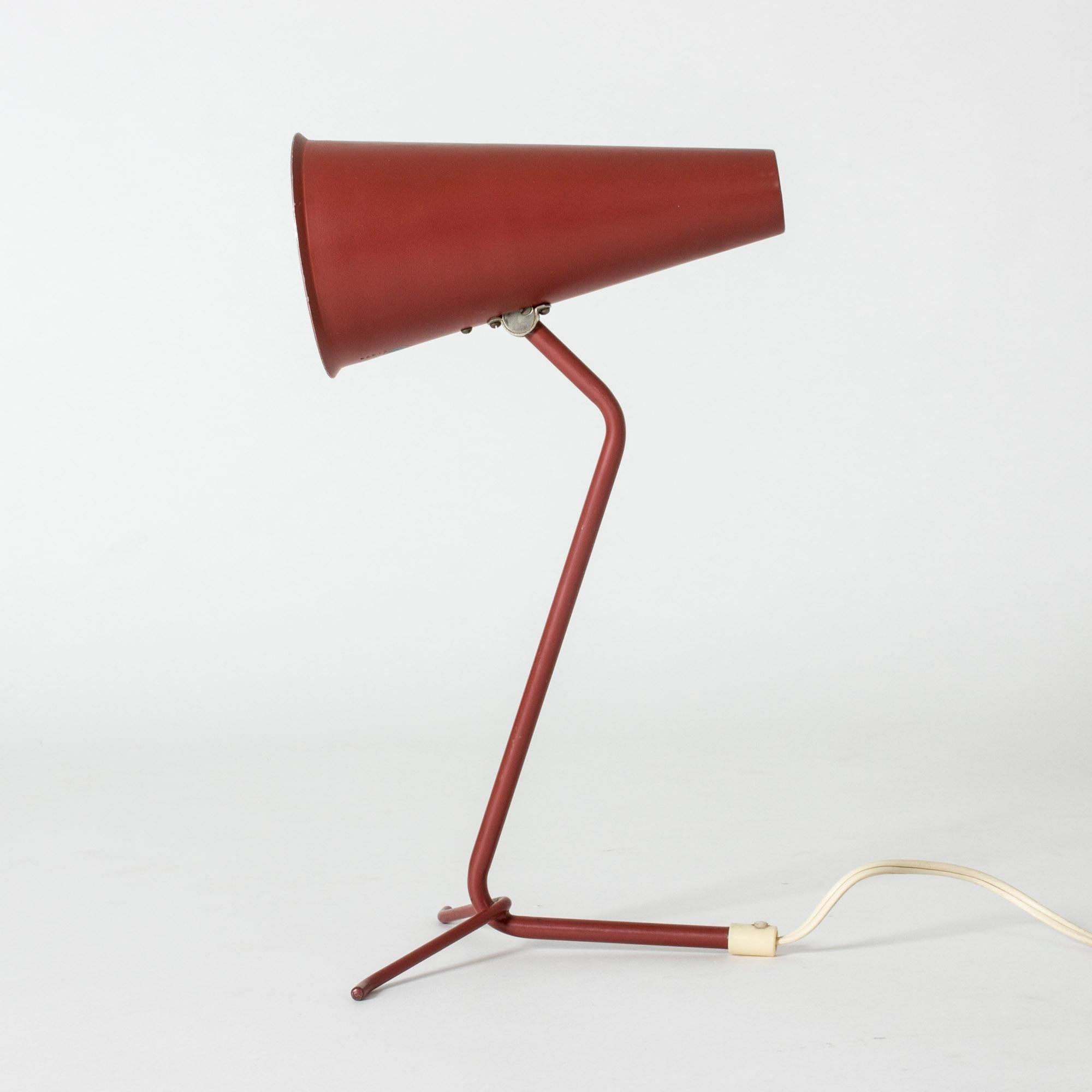 Lacquered metal table lamp from ASEA in a cool design with a long, conical shade. Dark red outside and white inside.