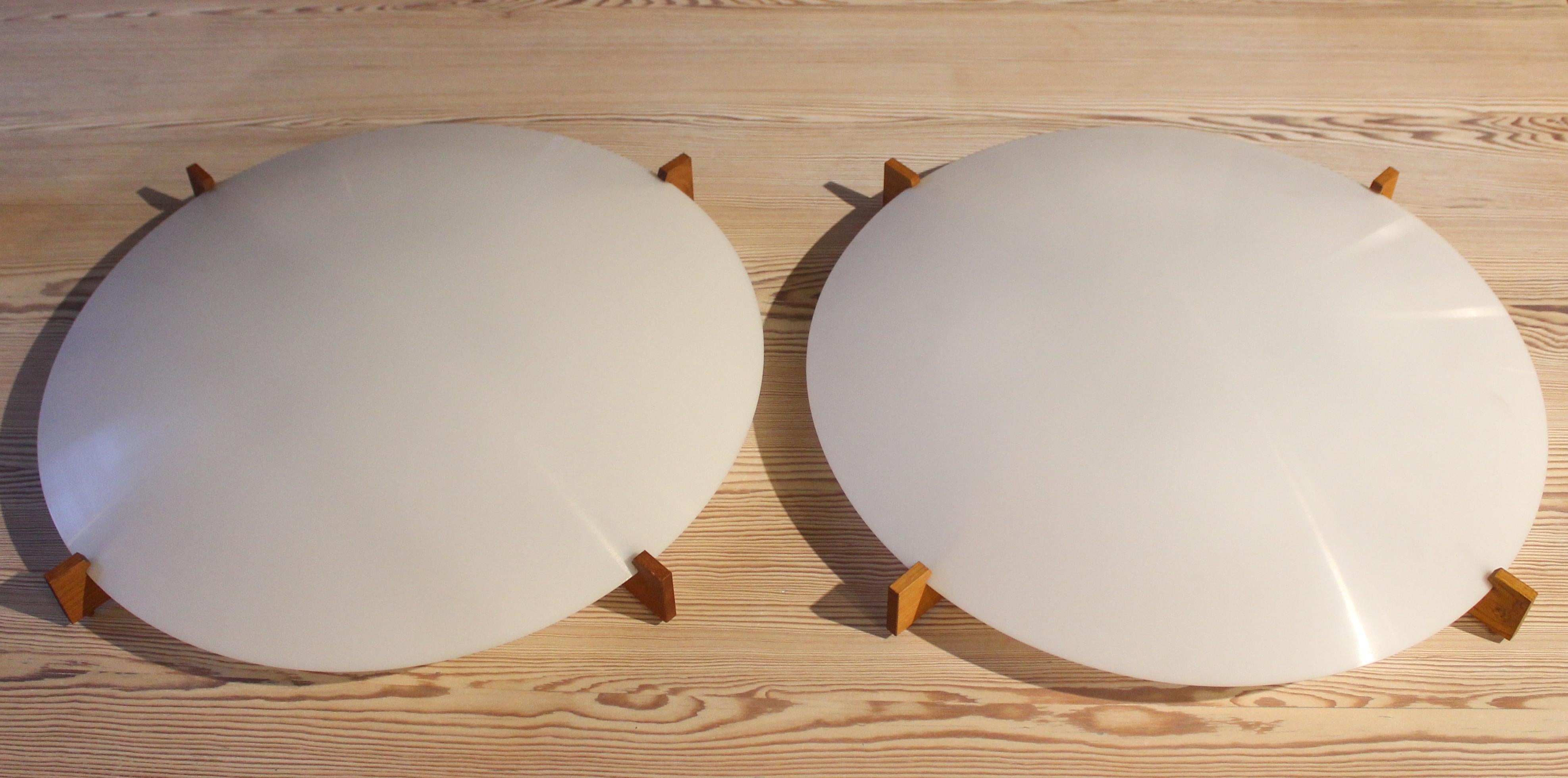 A pair of lamp scones designed by Uno & Östen Kristiansson for their company Luxus from Vittsjö, Sweden. These lamps were designed and produced in the 1960s. This is one of the larger models that measures 55 cm in diameter. The frame is made out of