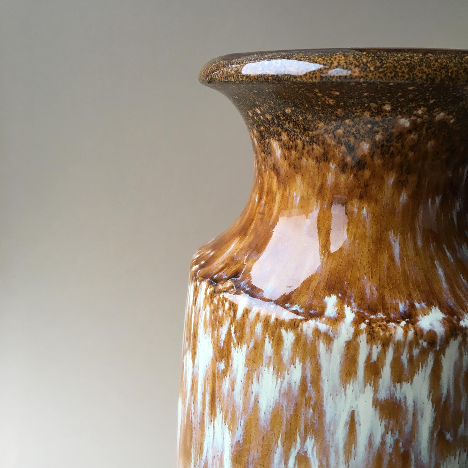 Fat Lava design refers specifically to a type of thick glaze that gives the object a thick lava-like look. This type of glaze was commonly used by German pottery manufacturers. 
This vintage vase features natural color pallet - brown, white, grey,