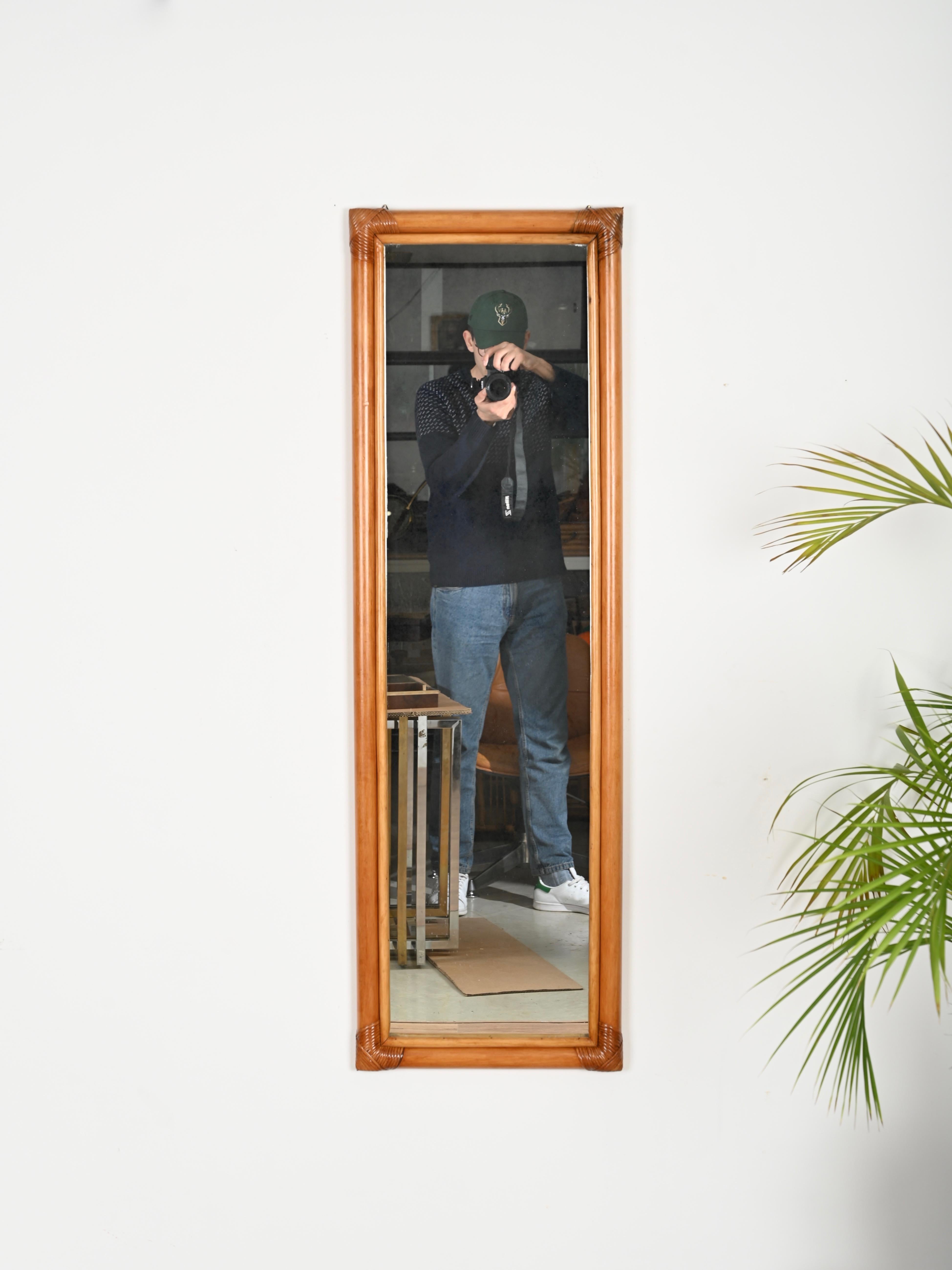 Wonderful large rectangular full-length midcentury mirror in bamboo and hand-woven wicker. This elegant organic mirror was designed in Italy during the 1970s. 

In fabulous condition and with a charming color. The mirror has a wonderful and sturdy
