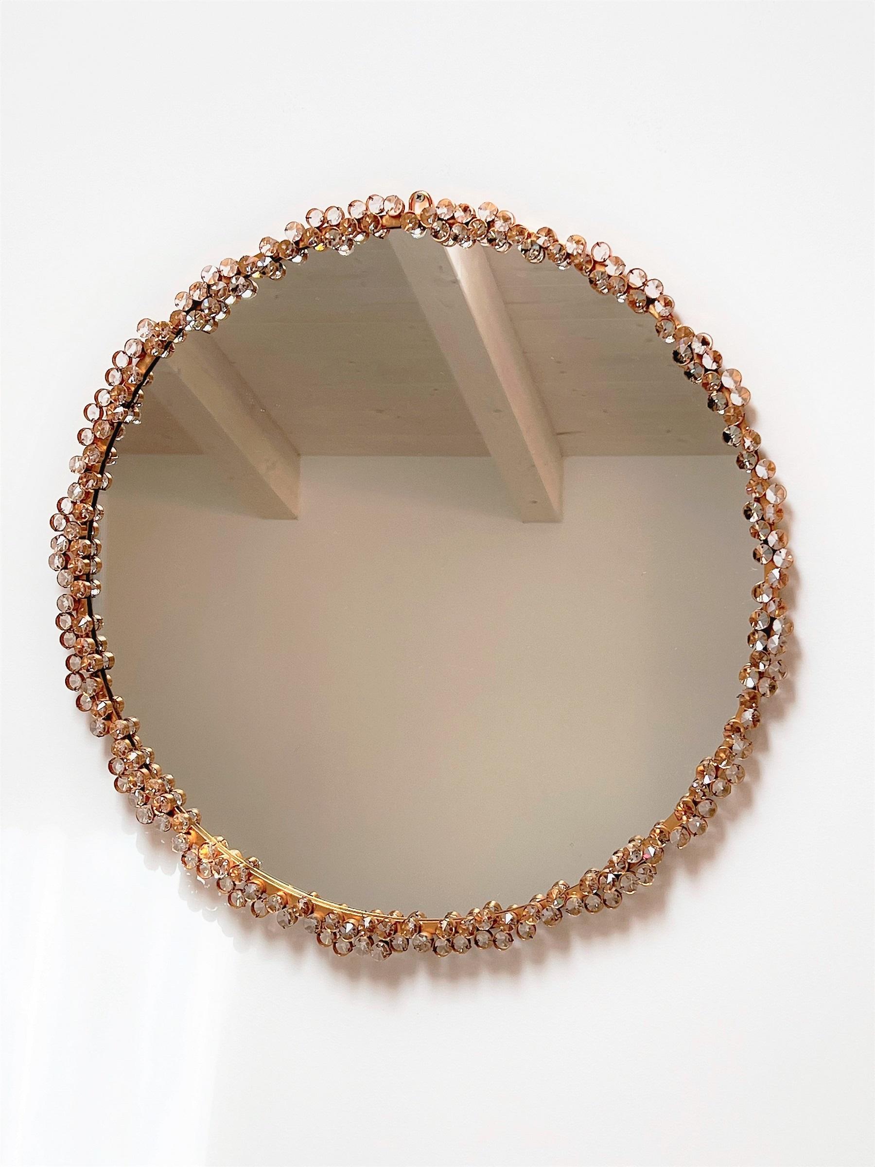 Magnifique miroir mural rond dans un cadre en laiton doré, avec d'innombrables pièces de cristal de qualité décorative fixées sur le cadre.
Fabriqué à Palme et Walter (Palwa), Allemagne, durant la seconde moitié du XXe siècle.
Palwa est connu dans