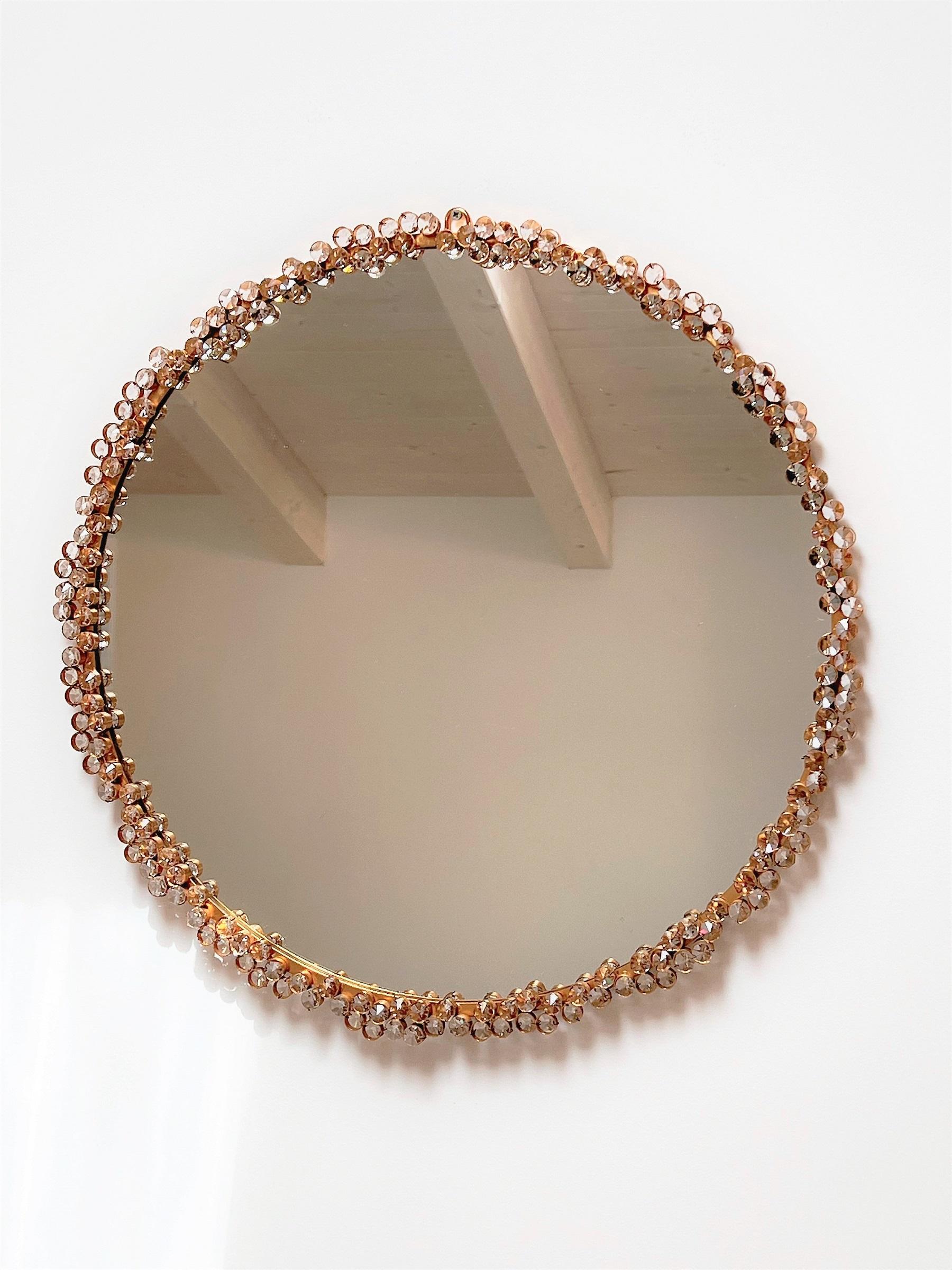 Gorgeous round large wall mirror in a gilt-brass frame, with countless decorative quality crystal pieces fixed on the frame.
Made from Palme and Walter (Palwa), Germany, during second half of the 20th century.
Palwa is worldwide well-known for its