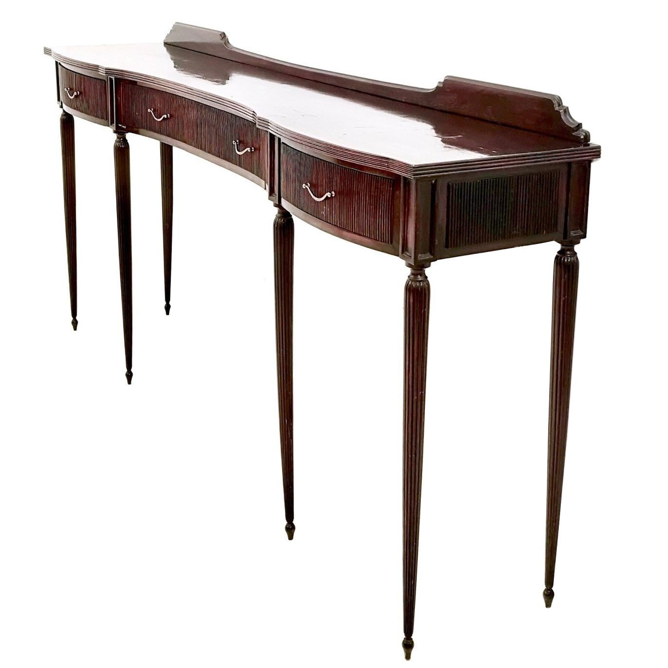 Made in Italy, 1950s.
It is made in walnut and features brass handles. 
This console may show slight traces of use since it is vintage, but it can be considered as in very good original condition and ready to become a piece in a home.
Its top may