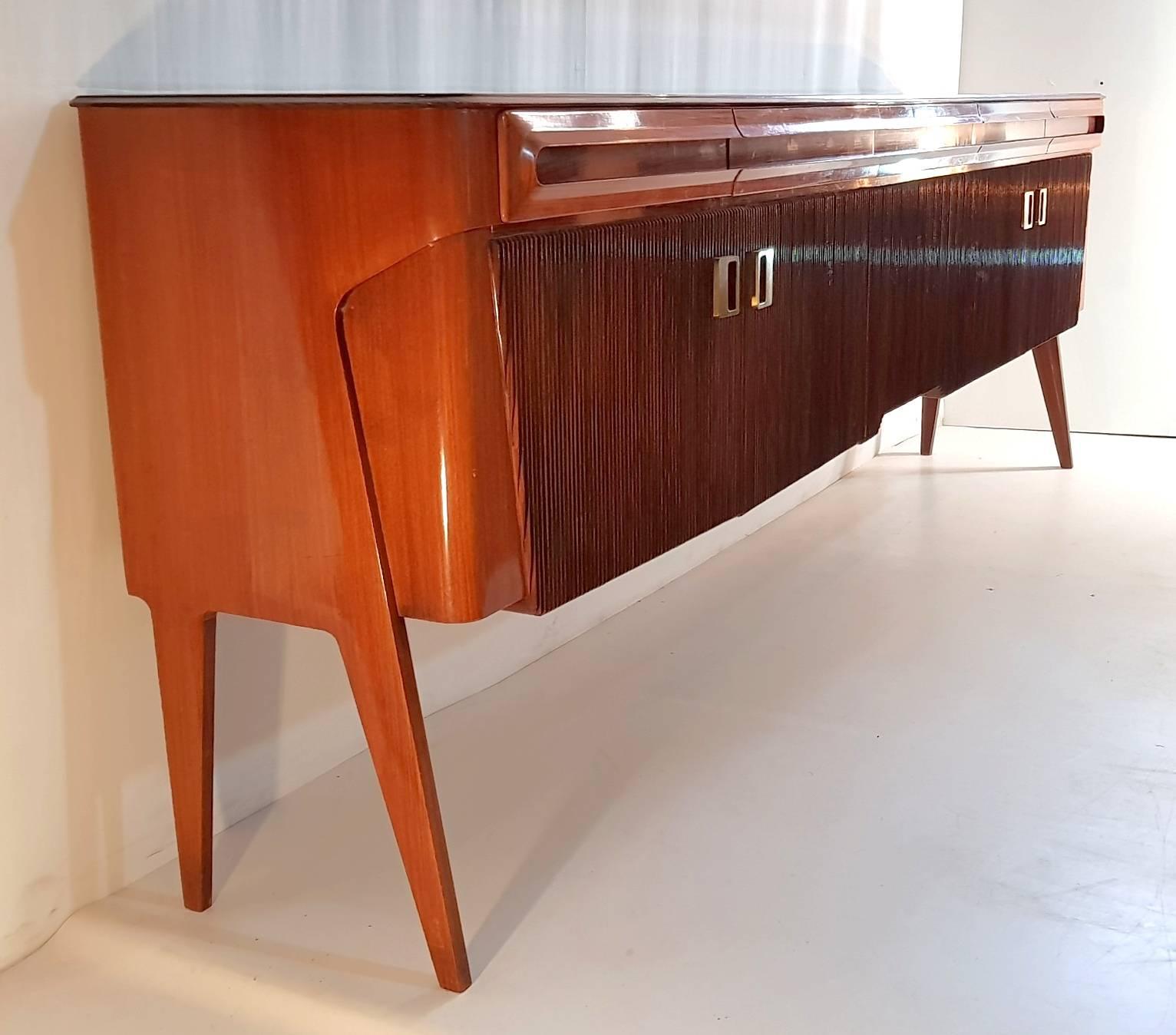 This sideboard/credenza was produced in Italy by the famous Galleria Mobili D´arte Cantu during the 1950s. It is unusually long measuring 2.90 meters (!) The top is made from dark brown opaline glass which also, as the rest of the piece is in great