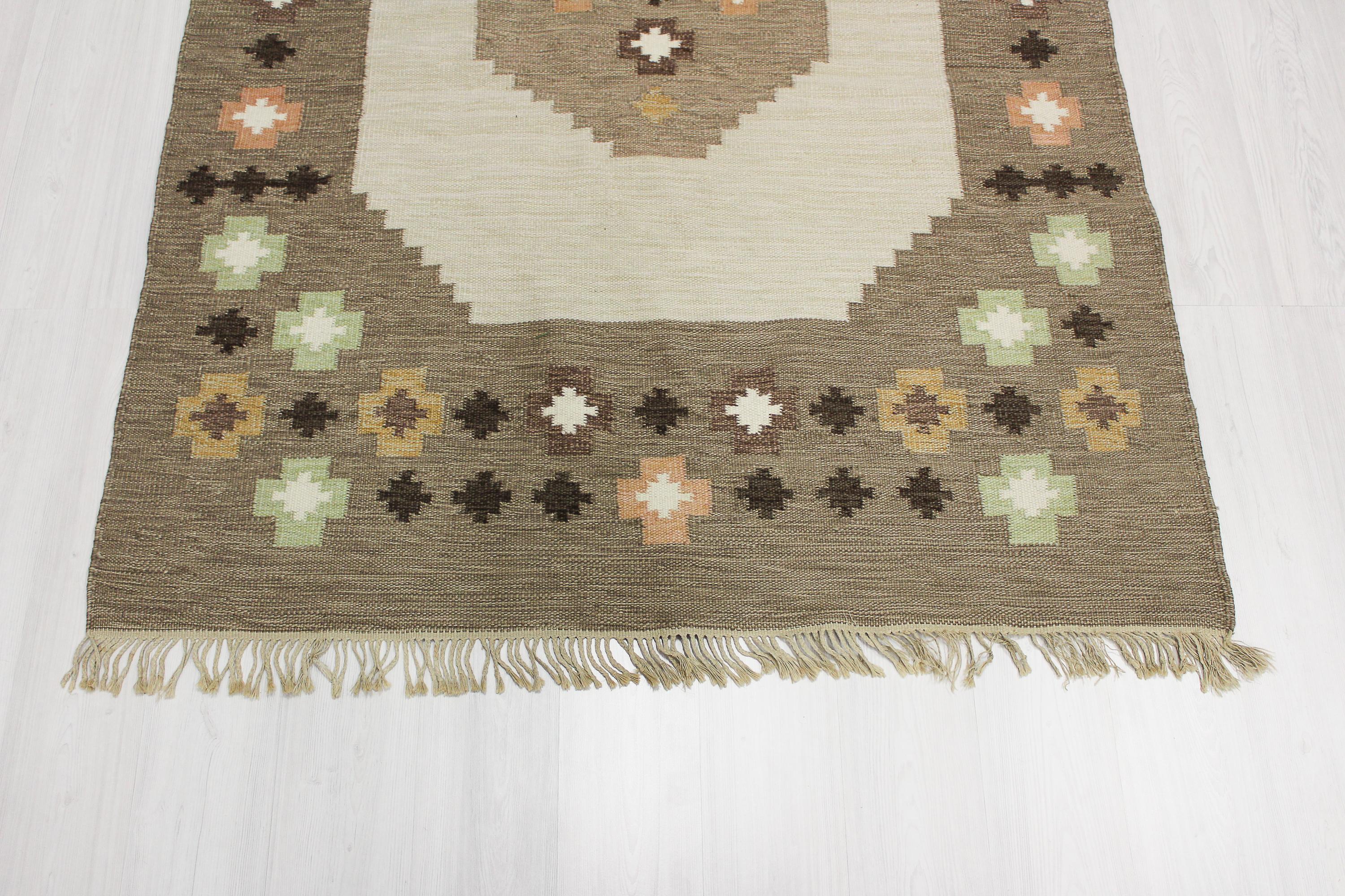 Midcentury Swedish flat-weave carpet with a light base and multicolored geometrical patterns. Excellent vintage condition with some smaller signs of usage on lashes.