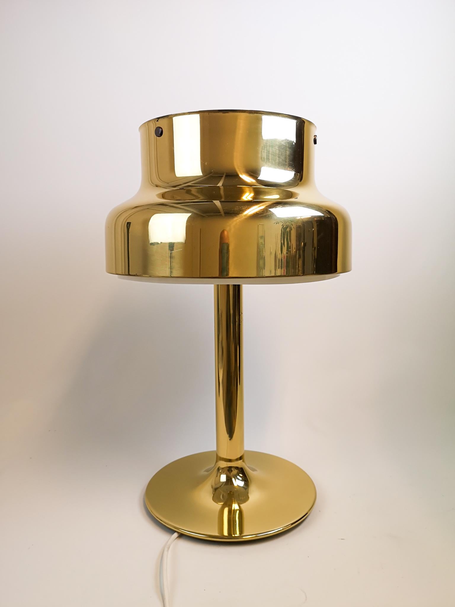 This 1960s table lamp, model Bumling, was designed by Anders Pehrson for Ateljé Lyktan in Åhus, Sweden. This table lamp with its brass features is a nice edition to your writing desk or table. 

Nice working vintage condition.

Measures: H 62