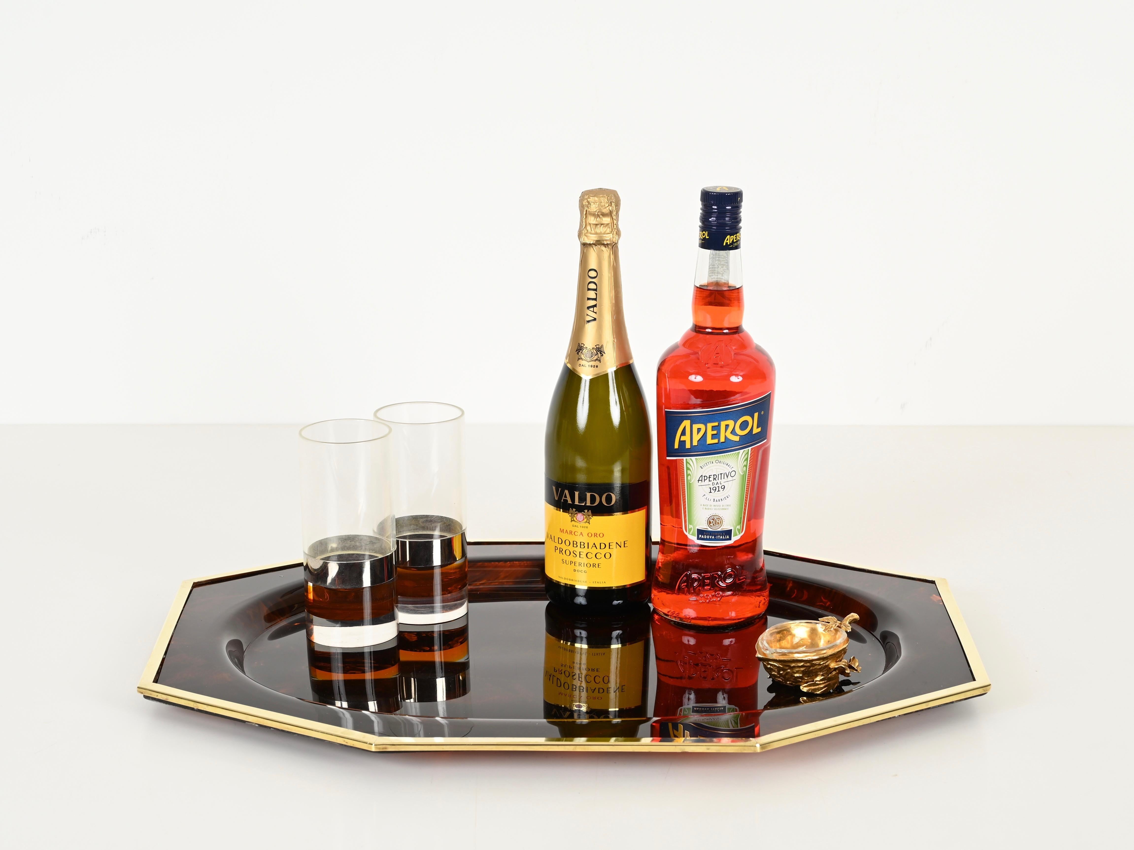 Marvelous midcentury large octagonal serving tray in a charming tortoiseshell effect lucite and brass.  This incredibly stylish and unique piece was designed in Italy during the 1970s.

In fabulous conditions with chips or cracks. The lucite has a