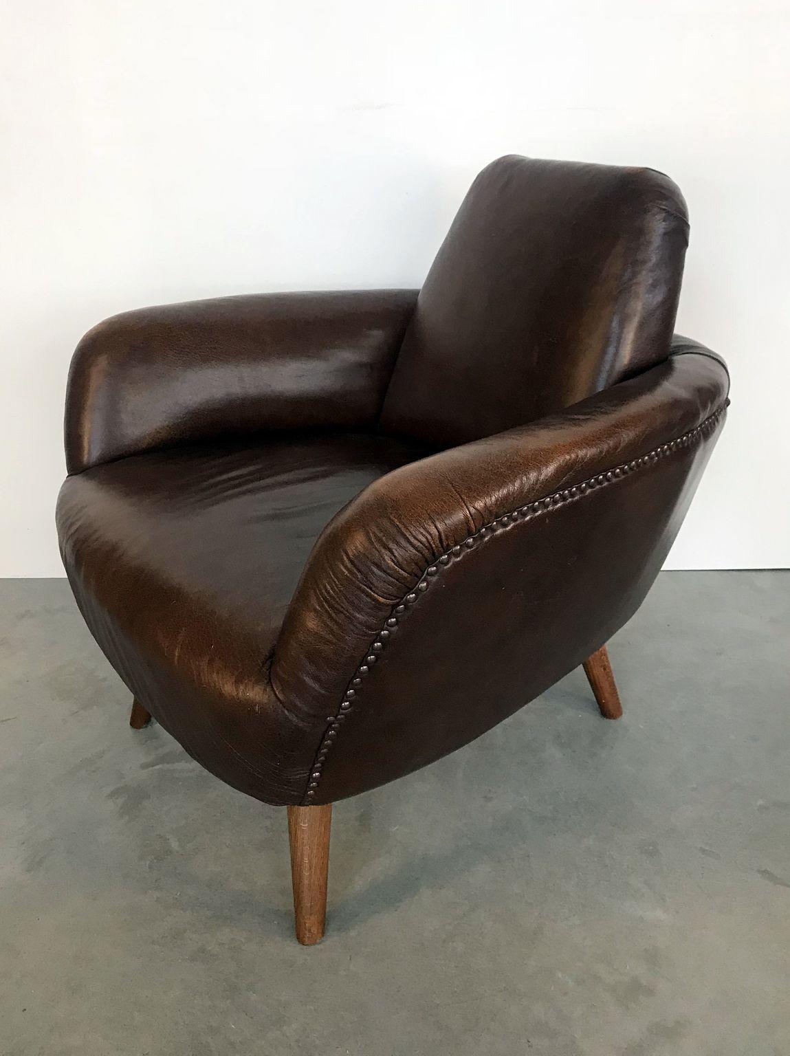 Armchair on beechwood legs with riveted leather seating from former Yugoslavia.