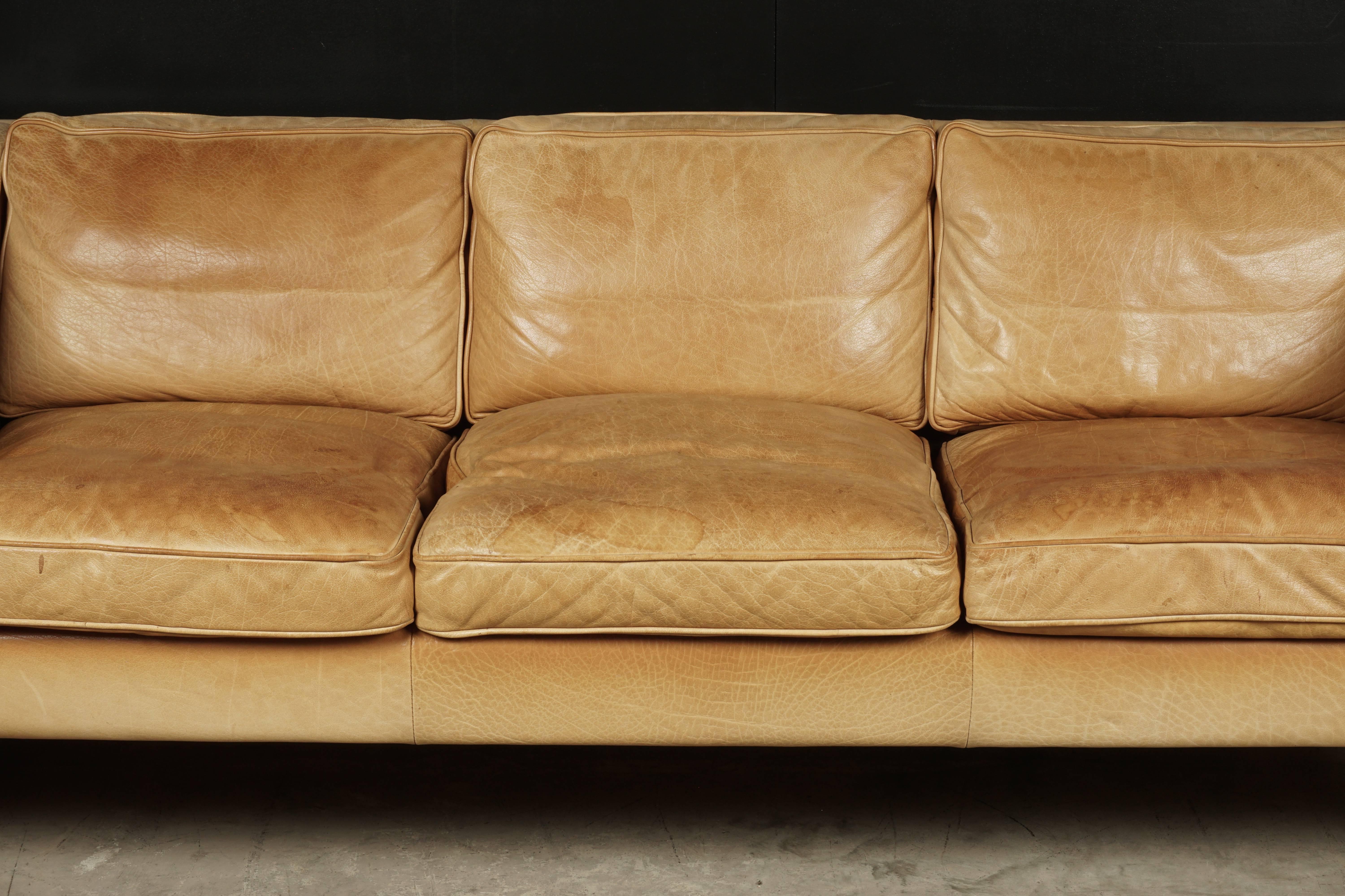 Midcentury leather sofa from Denmark, circa 1970. Fantastic cognac leather color with feet made of birch.