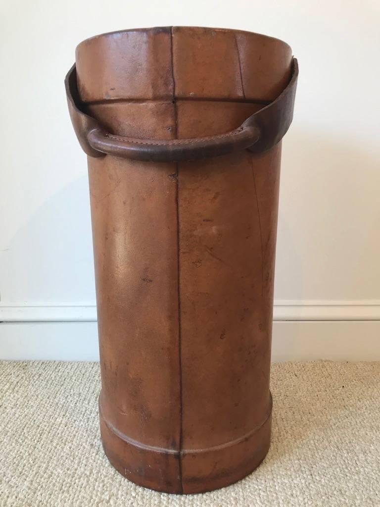 We are not sure why this leather bucket was made, but it certainly is reminiscent of the fire buckets of the 18th and 19th century probably made mid-20th century, the leather and handle show great signs of wear. Ideal for umbrellas, kindling,