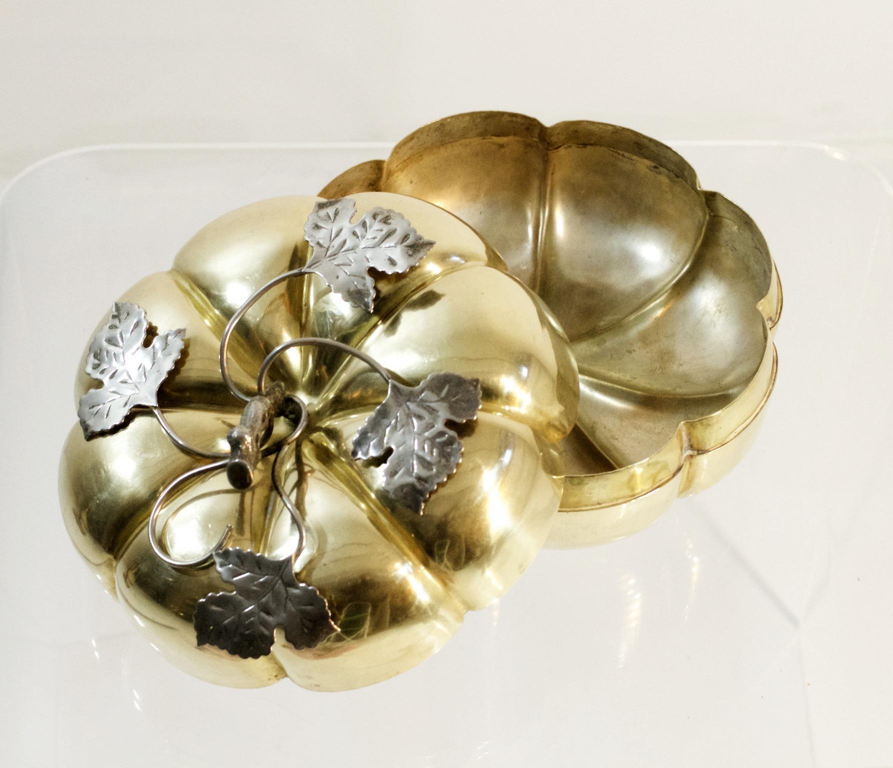 A wonderfully large handcrafted box in the shape of a pumpkin in brass with decor of swooping leaves and vines in silver metal on the lid.