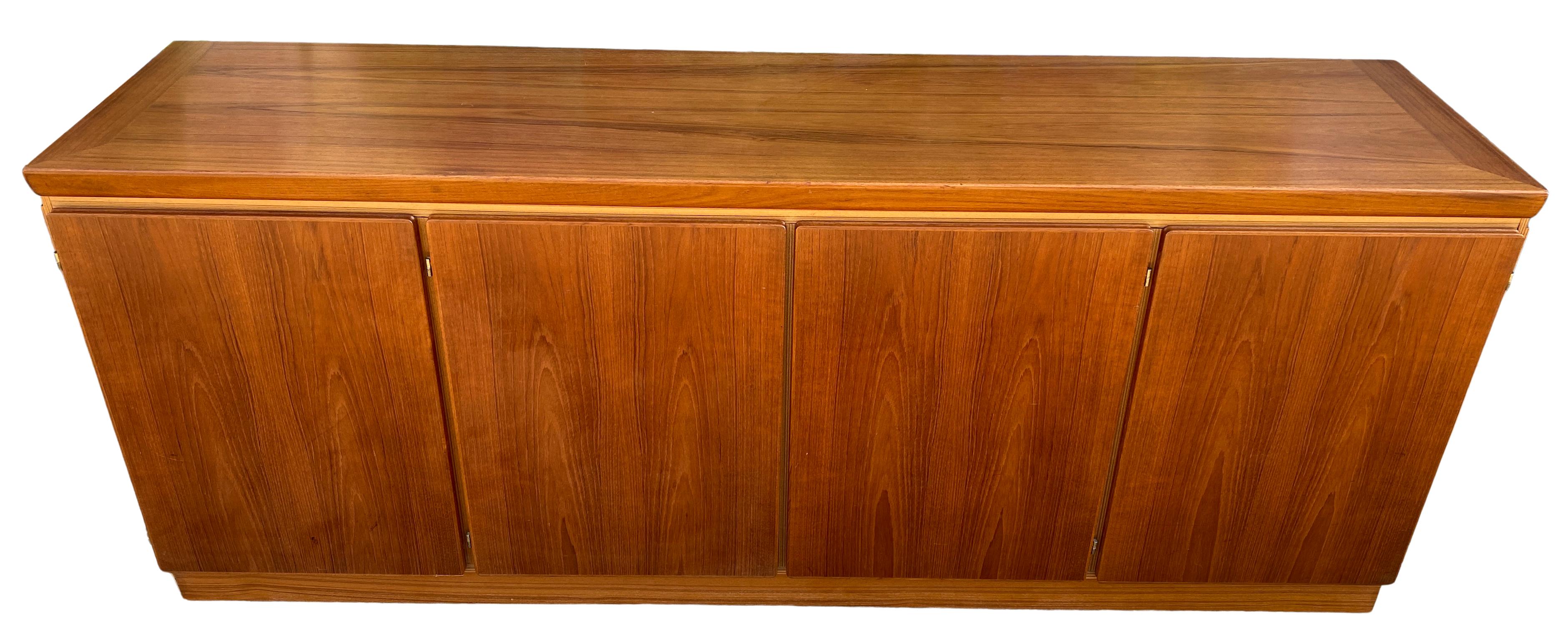 Midcentury long Danish modern teak credenza sideboard with 4 doors and 5 drawers also has 3 adjustable shelves. Very clean teak wood credenza with sculpted teak doors. Very clean midcentury Danish sideboard. Great looking all drawers are clean and