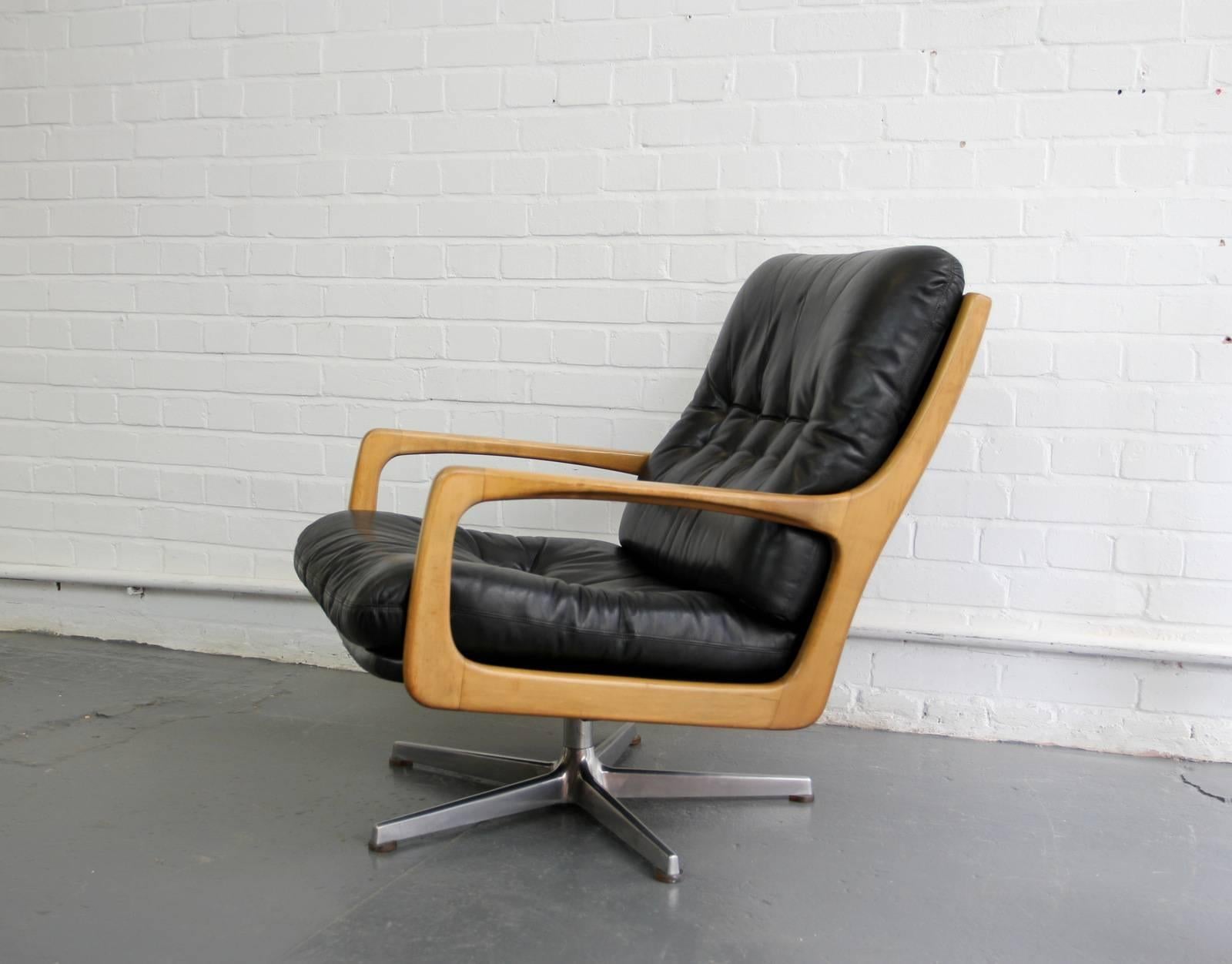 Midcentury lounge chair by Eugen Schmidt, circa 1960s.

- Black leather button back
- Beautifully shaped Beech arms
- Turns 360
- Designed by Eugen Schmidt
- German, circa 1960s.
- Measures: 67cm wide x 86cm tall x 80cm deep
- 40cm from the