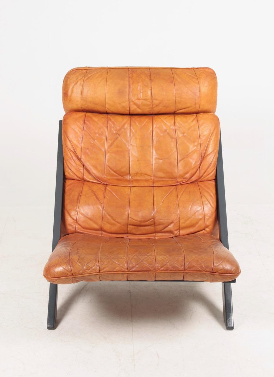 Lounge chair in patinated leather by De Sede. Original condition.
