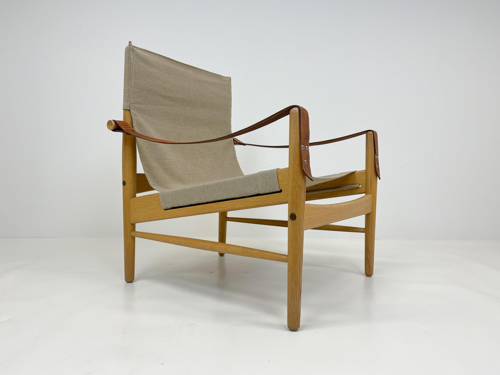 Beautiful safari chair designed by Hans Olsen for Viska Möbler in Kinna, Sweden.
This chair is made of oak with a new canvas Swedish quality linen upholstery.

Good vintage condition oak frame with the leather armrests with nice patina. Excellent