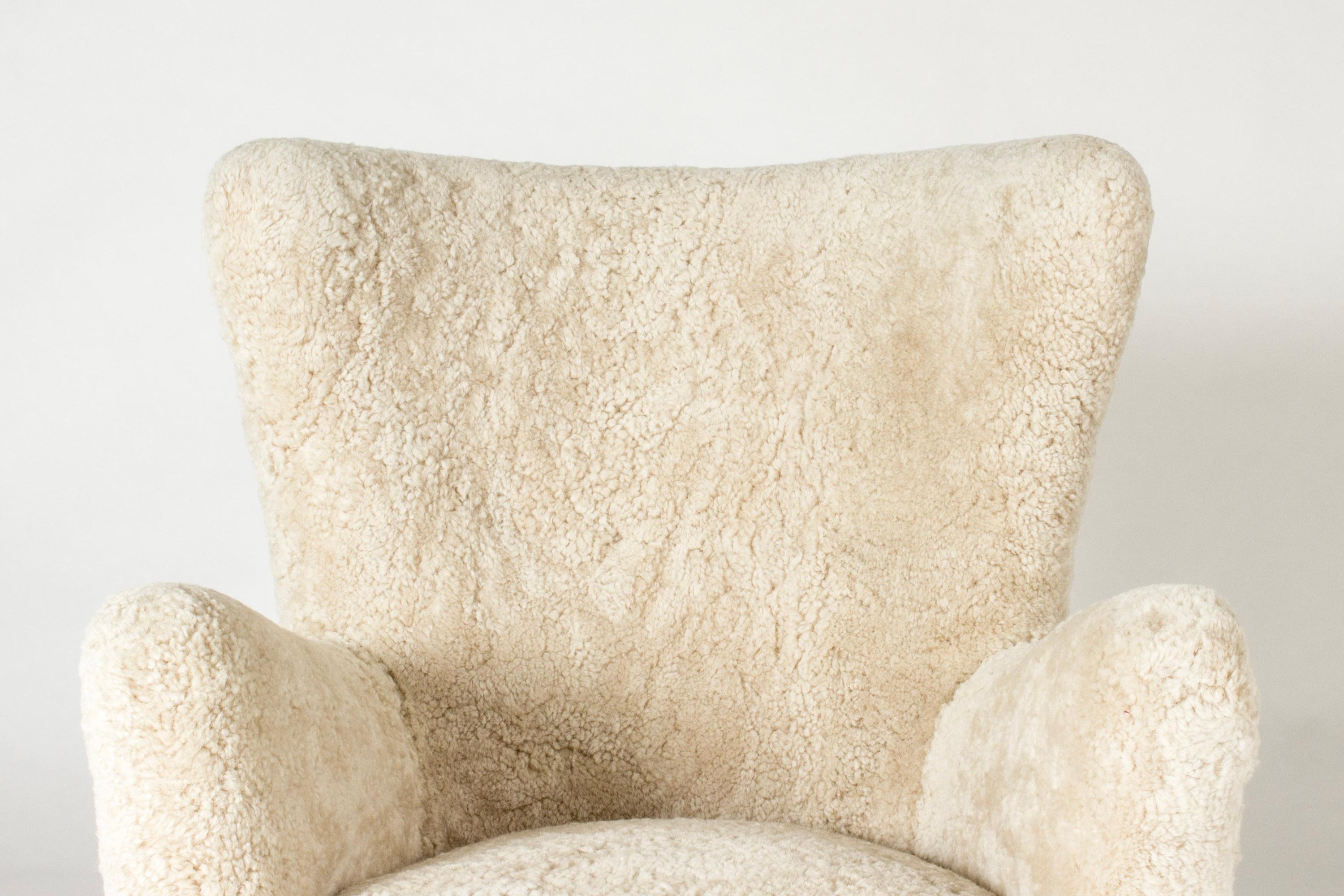 Elegant 1940s lounge chair by Kai Kristiansen, with clean lines. Upholstered with sheepskin that adds extra comfort to this beautiful chair.