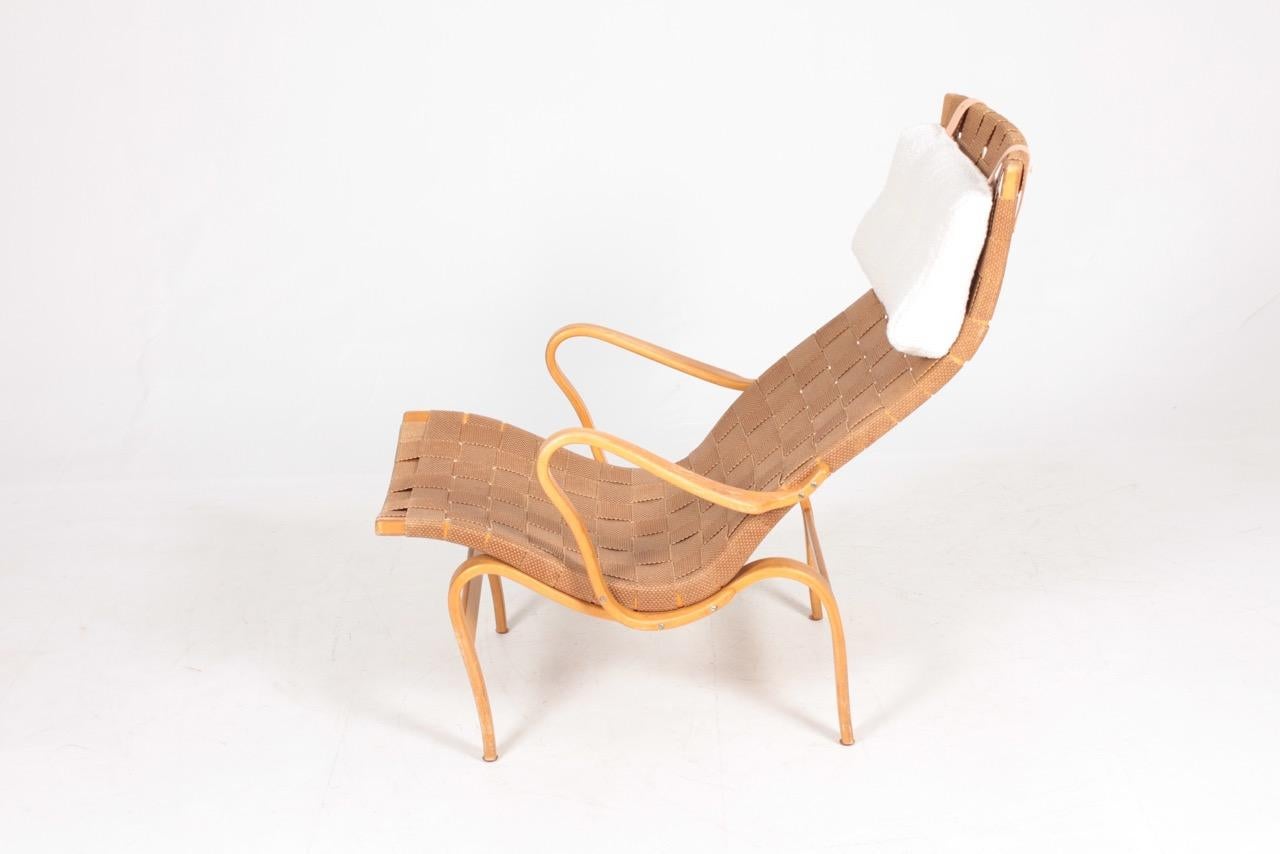 Bruno Mathsson lounge chair with canvas webbing and reupholstered cushion in bouclé wool. Seat frame, arms and underframe of laminated beech. Produced by Firma Karl Mathsson, made in 1967. Great original condition

Bruno Mathsson was born to