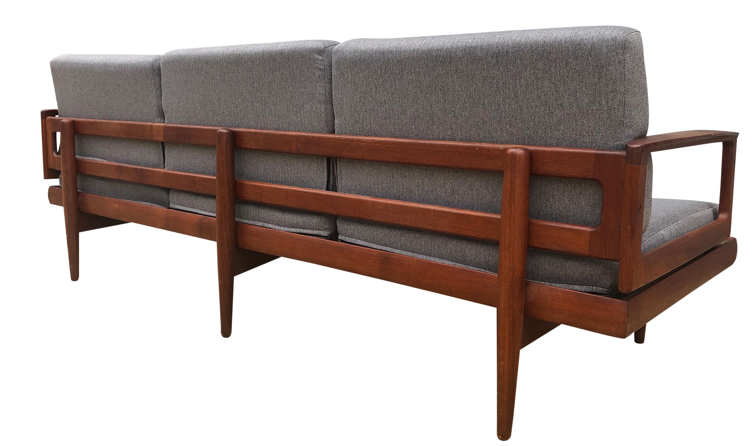 Beautiful vintage 1960s low Danish three-seat sofa daybed with amazing solid Teak wood frame with original patina has all new Pirelli rubber upholstery straps. Has modern grey cushions with grey herringbone woven upholstery in great condition. Made