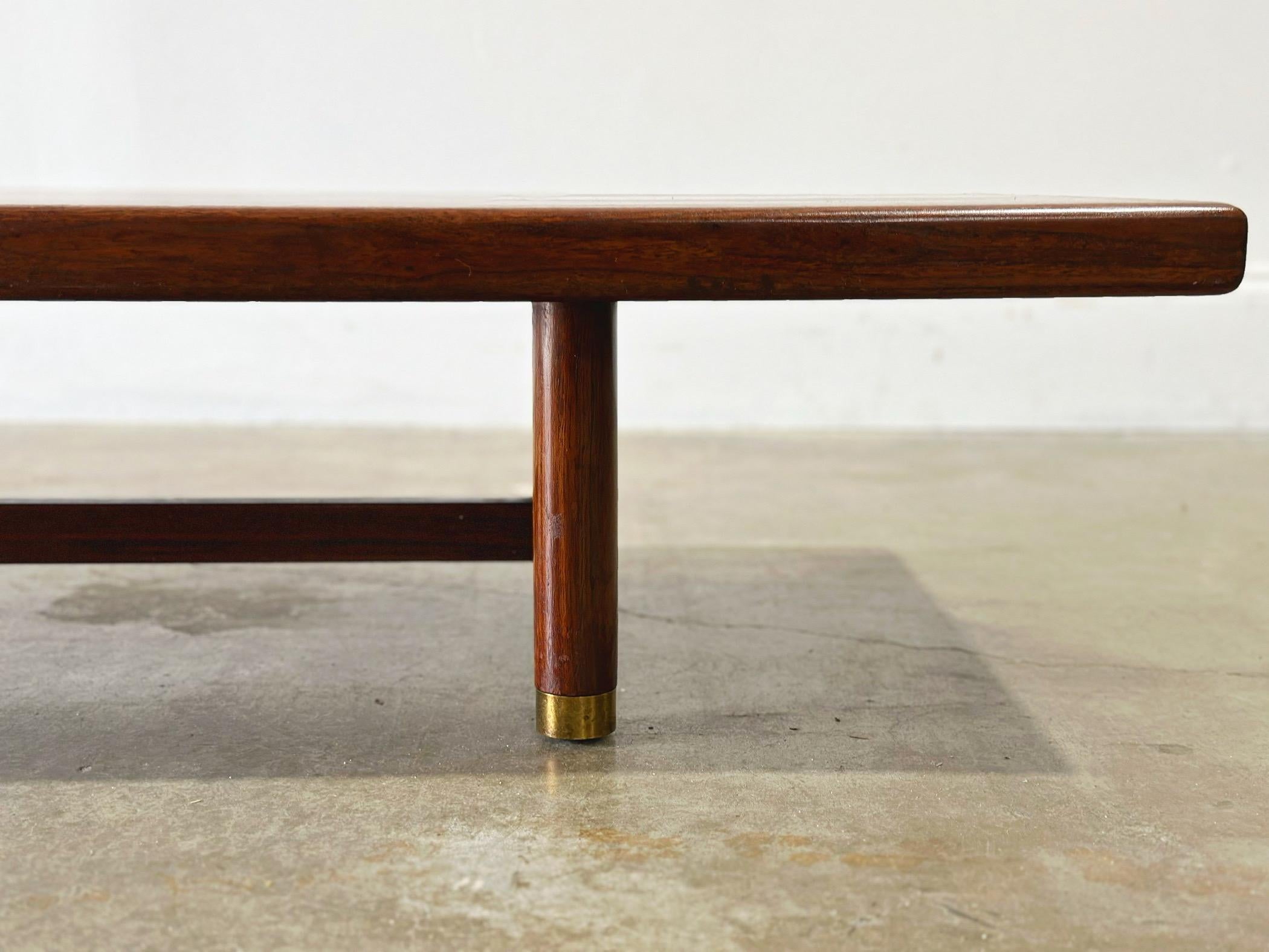 Long and low cocktail table or bench in walnut by Gordon's fine Furniture circa 1950s. Perfect for an entryway. Brass sabots. 
This table has been attended to and restored by our team - it is in excellent condition and is ready for use.