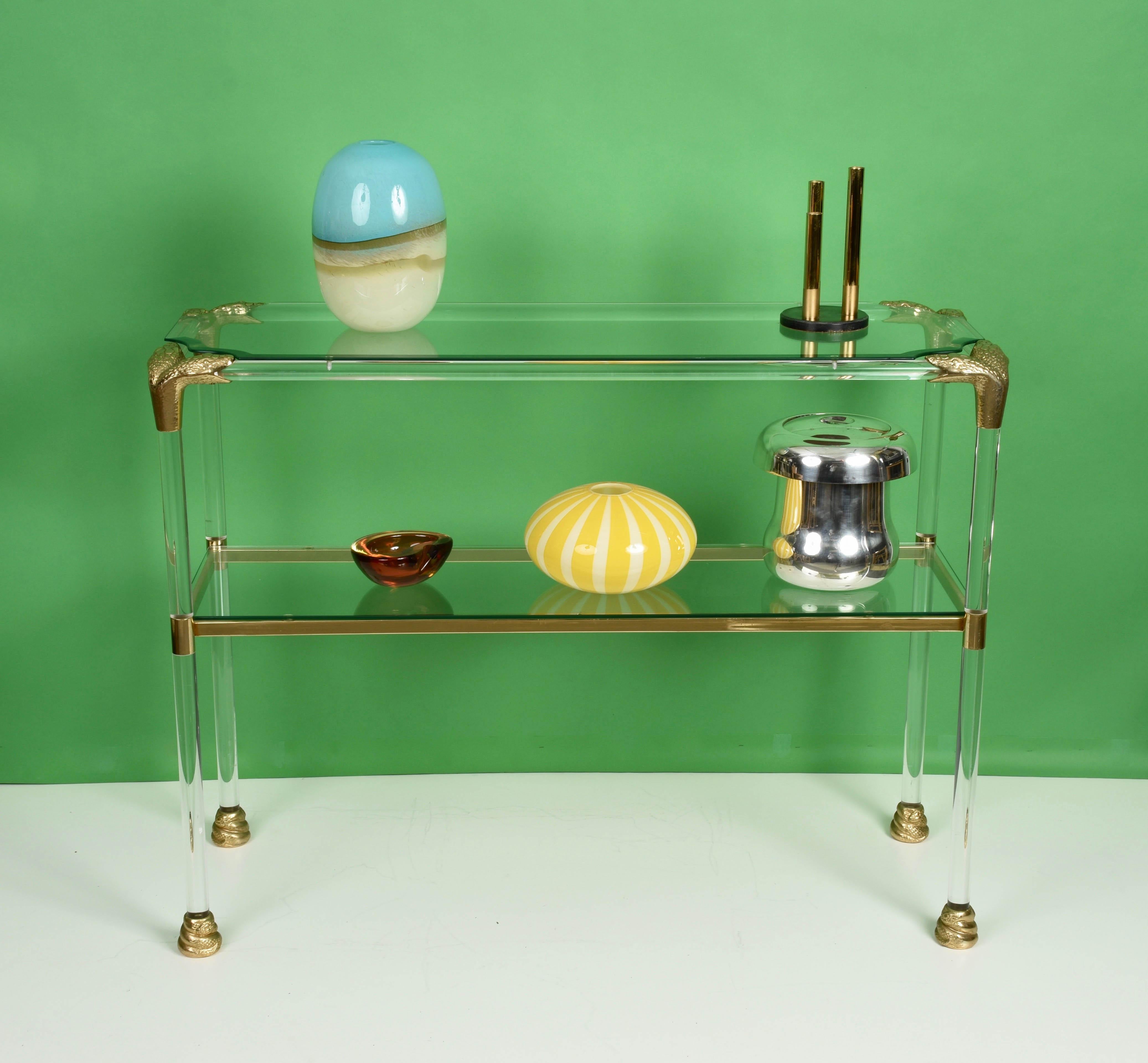 Midcentury Lucite and brass étagère with snakehead finishes. This unique item was designed during the 1970s in Italy.

This elegant console table is marvellous as it has snakehead brass corners and brass snake bodies as feet.

A bold piece of