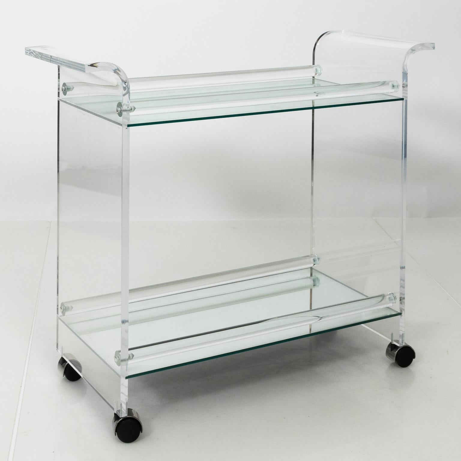Lucite barcart with mirrored top on wheels with curved handles, circa mid-20th century.
 