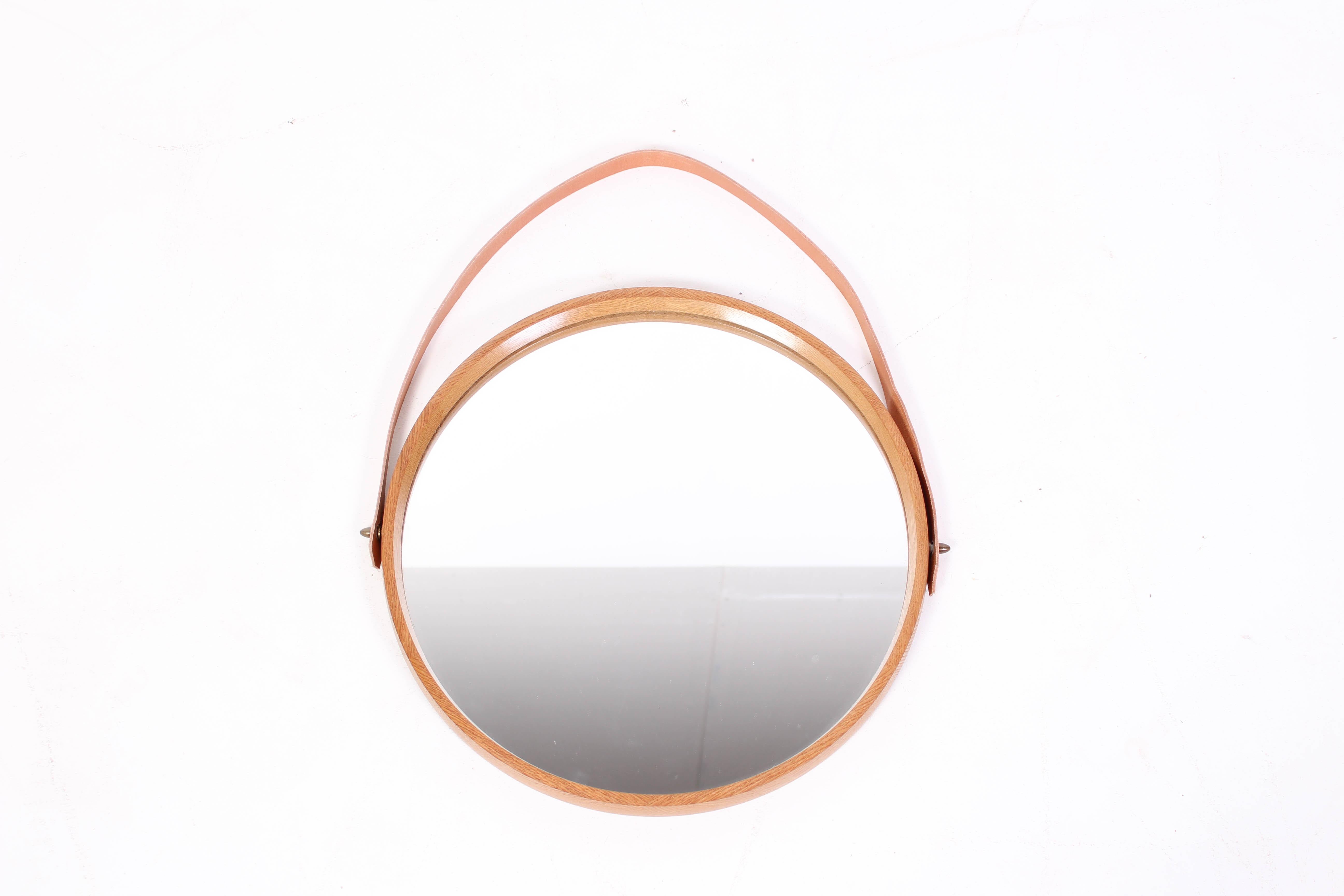 Midcentury oak mirror with leather strap and brass fittings by Uno & Östen Kristansson. The mirror was produced by their company Luxus from Vittsjö, Sweden.

Very good vintage condition, new leather strap.
