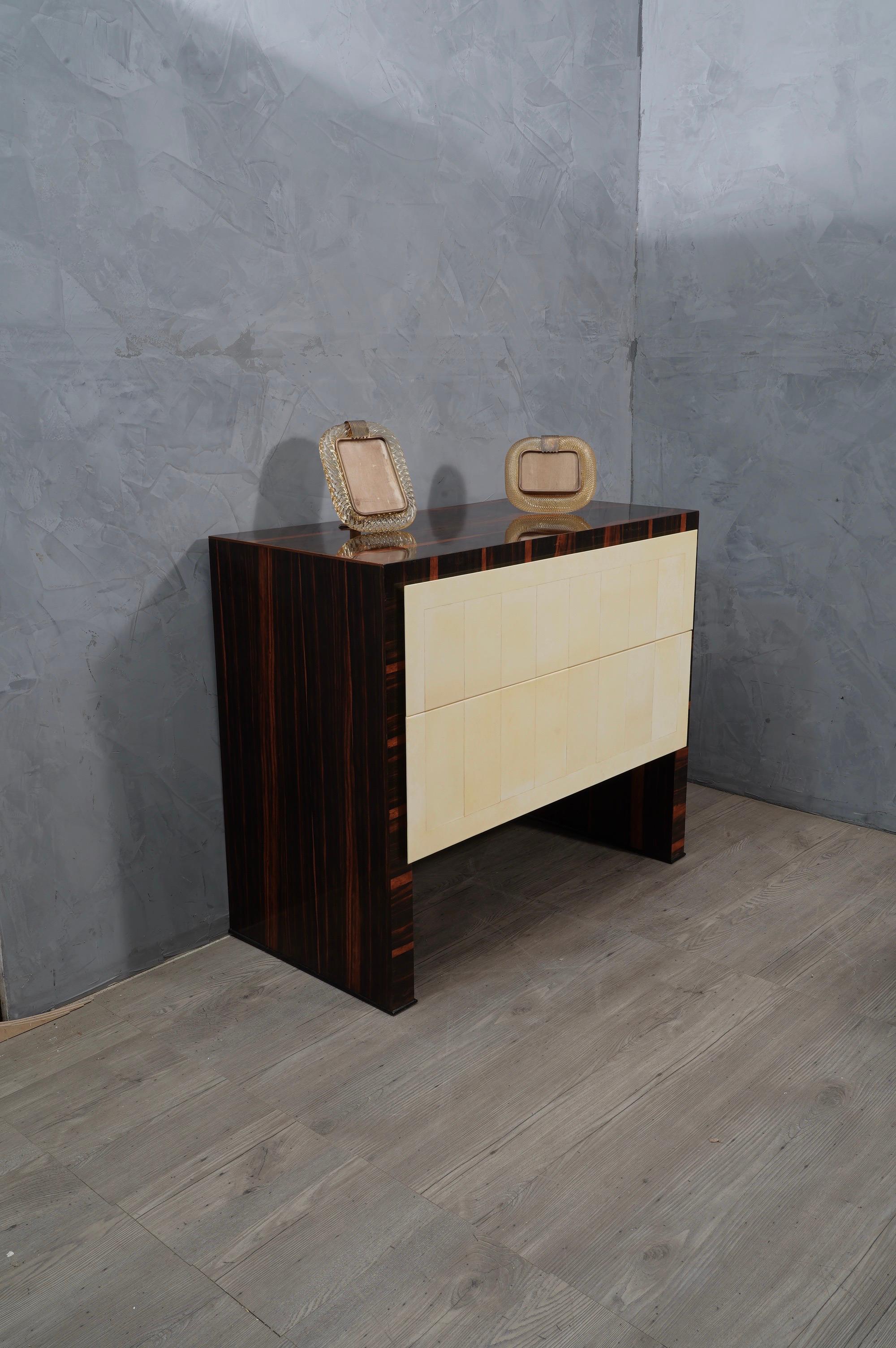 Perfect bedroom dresser all refinement and style both for the size of the entire design and for the utmost care taken for its entire finish.

A simple square design welcomes a Macassar wood veneer, with two front drawers covered in goatskin instead.