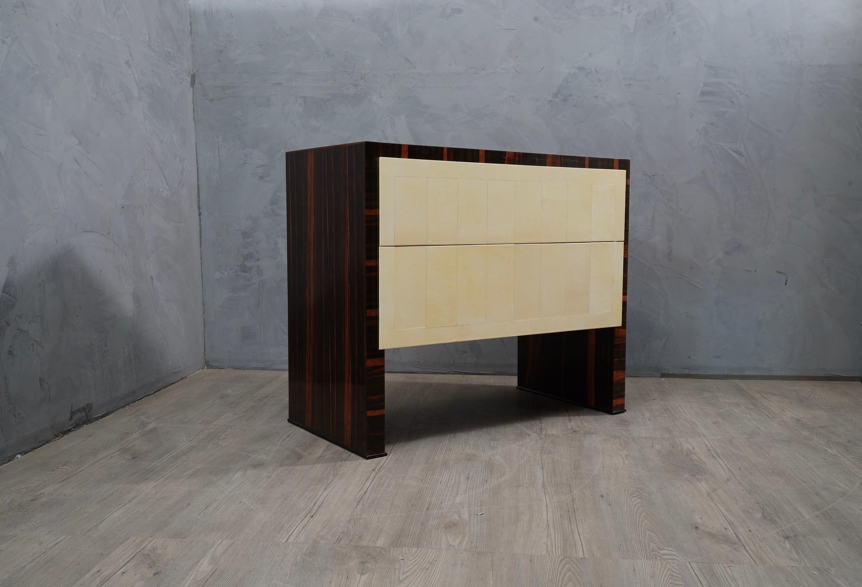 Perfect bedroom dresser all refinement and style both for the size of the entire design and for the utmost care taken for its entire finish.

A simple square design welcomes a Macassar wood veneer, with two front drawers covered in goatskin instead.