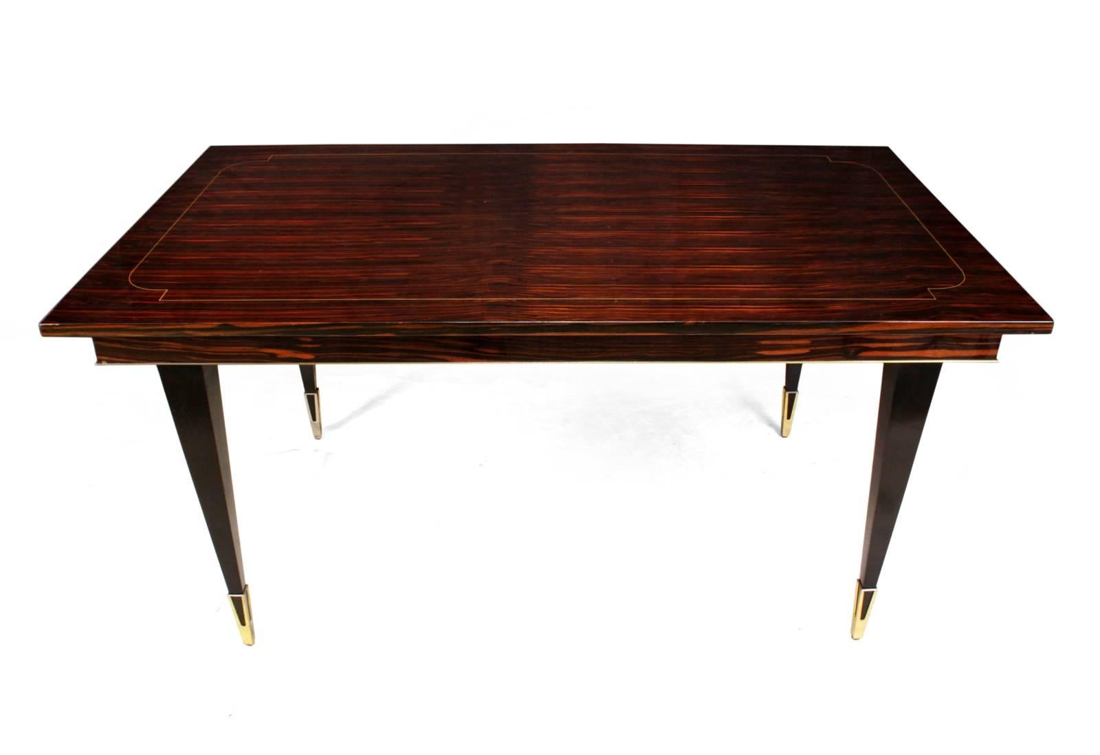 Midcentury Macassar ebony dining table
A midcentury dining table produced in France in the mid-1950s. With Macassar ebony with fine line inlay and adjustable brass feet, there are two extension leaves

the table is still in its original thick