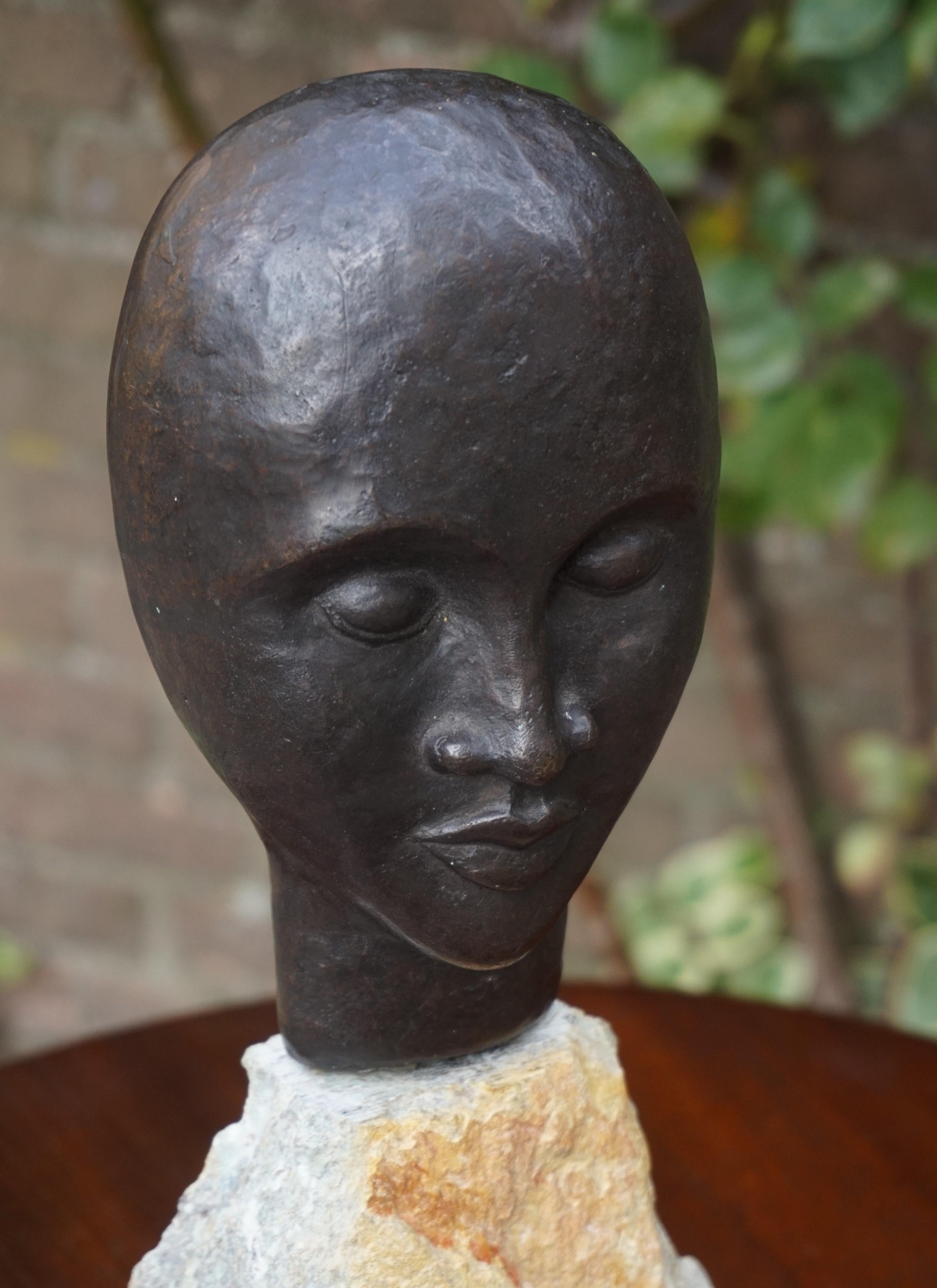 Moderne Sculpture en bronze d'un homme africain serein réalisée au milieu du siècle dernier sur un socle en pierre calcaire