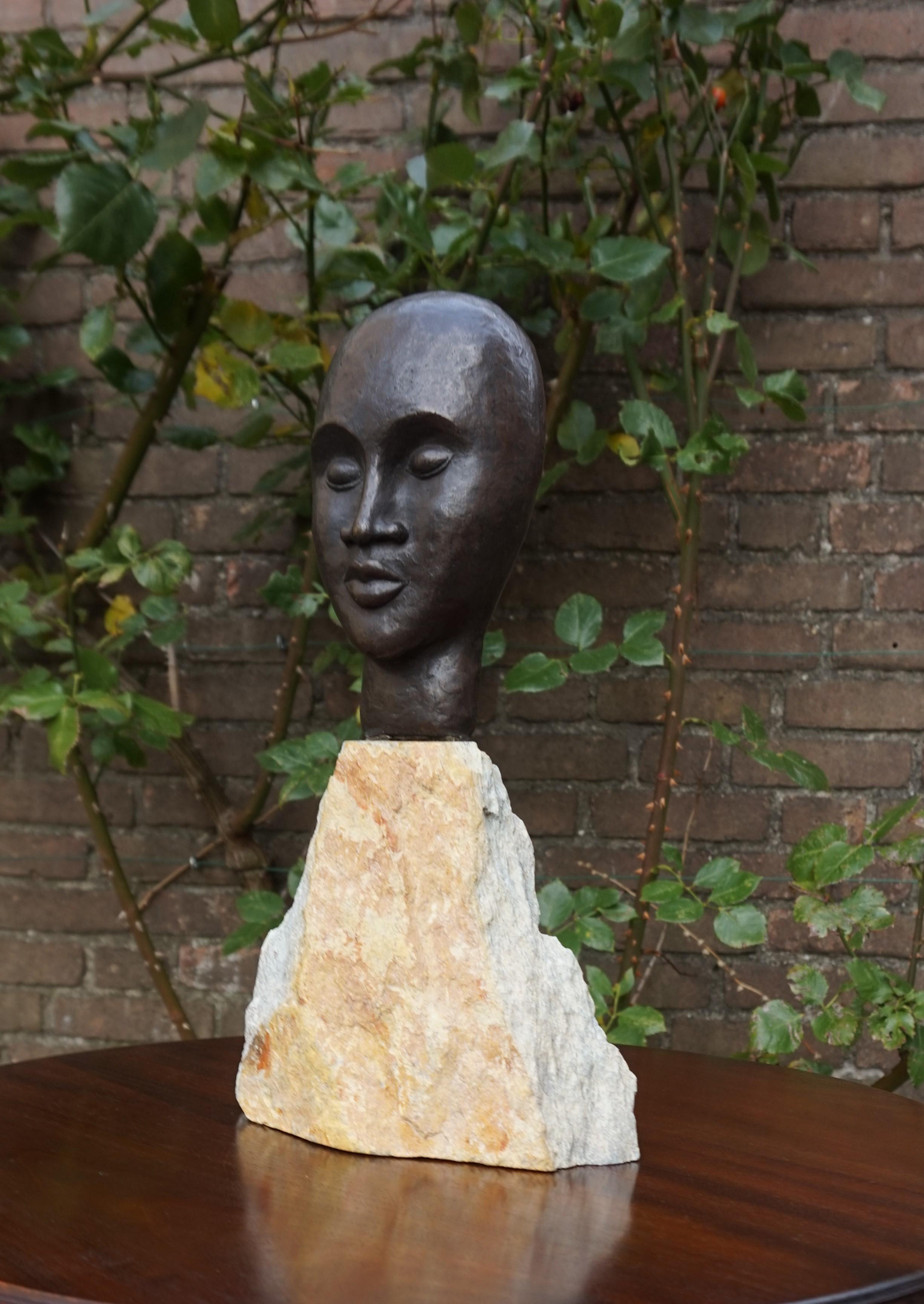 Bronze Sculpture en bronze d'un homme africain serein réalisée au milieu du siècle dernier sur un socle en pierre calcaire