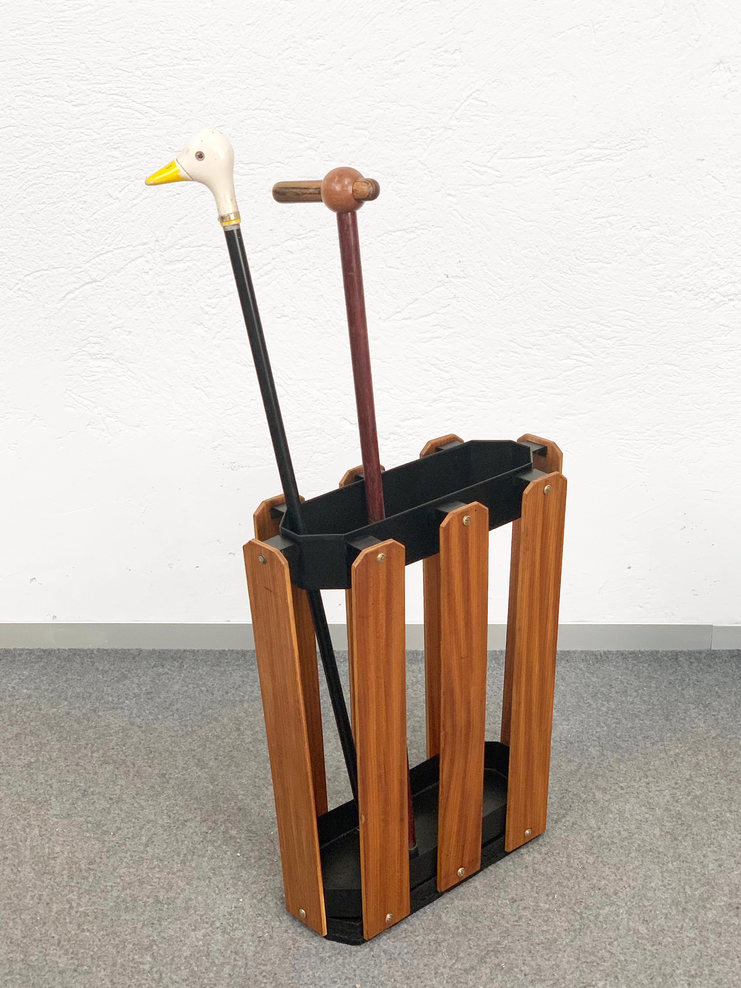 A wonderful Italian umbrella stands from the 1970s, made of wood and black metal.

The item is in good condition and it could be used as a cane holder too. A marvellous piece for an entrance hallway.

Measures (cm):
Depth 18
Width 47
Height 51.
