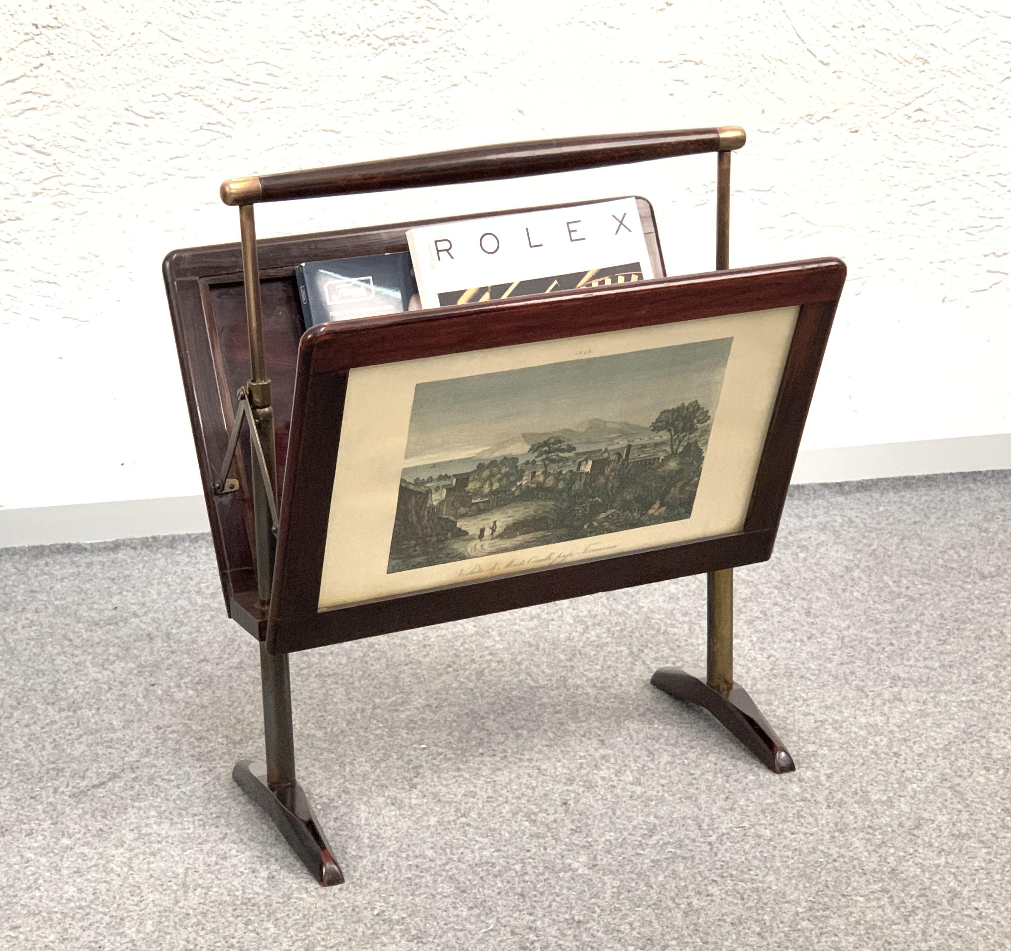 Amazing midcentury wood and brass folding magazine rack. This item was produced in Italy during 1950s in the style of Ico Parisi.

This folding magazine rack is marvellous as it has two watercolour landscapes engravings on each side affixed behind