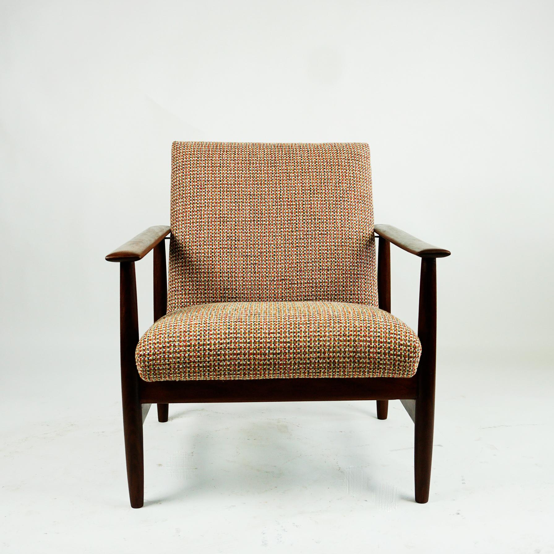 This light and highly comfortable Easy or Lounge chair was produced by Knoll Antimott, Germany in the 1960s. It features a brown mahogany wood frame and newly upholstered with top quality fabric cushions in different warm colours like soft orange,