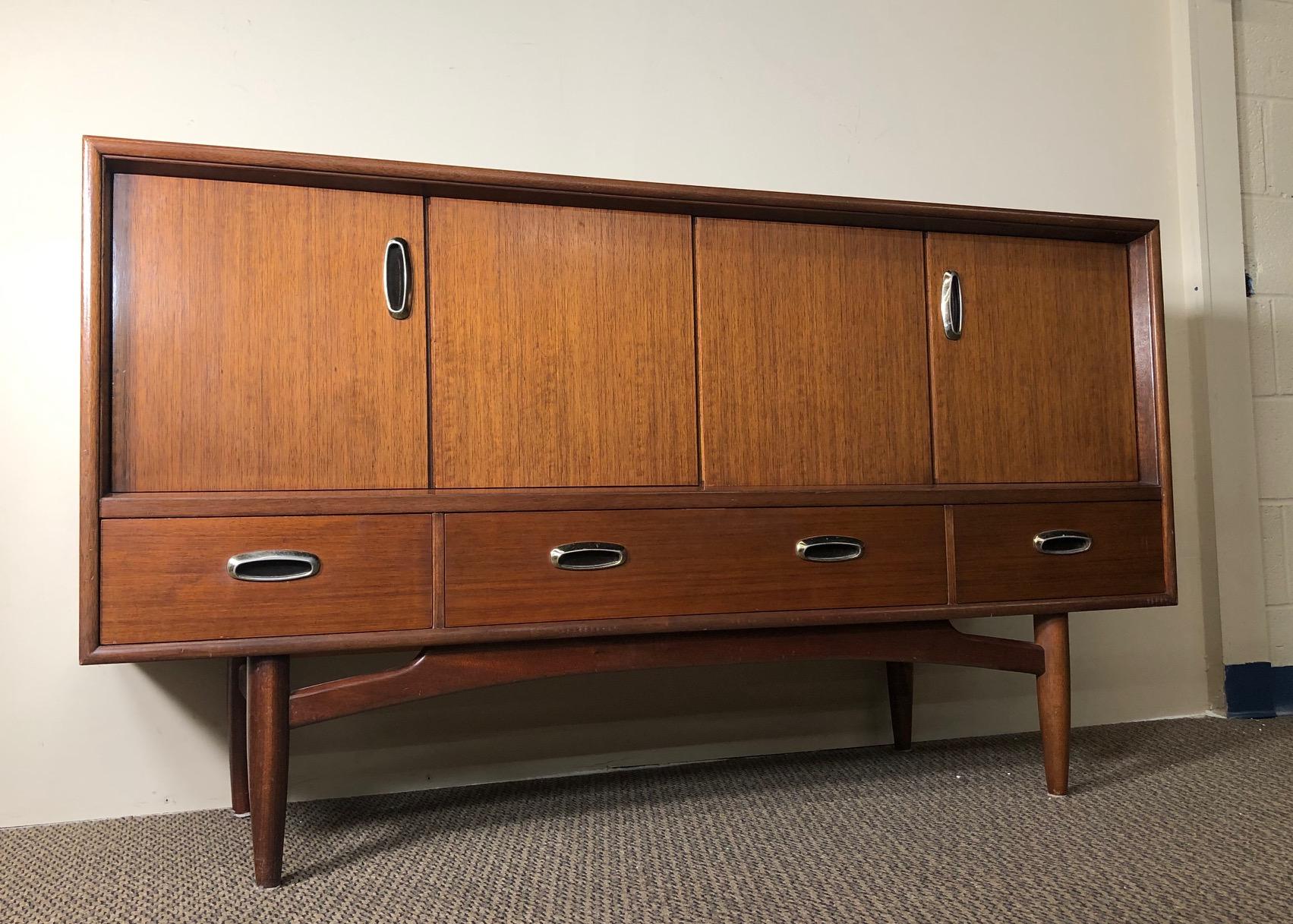 Stunning midcentury credenza by G Plan. Mahogany with metal pulls. Featuring unique folding doors with a fixed shelf inside. Three drawers all open and close easily. Clean interior. Original G Plan sticker in the middle drawer.
Excellent condition.