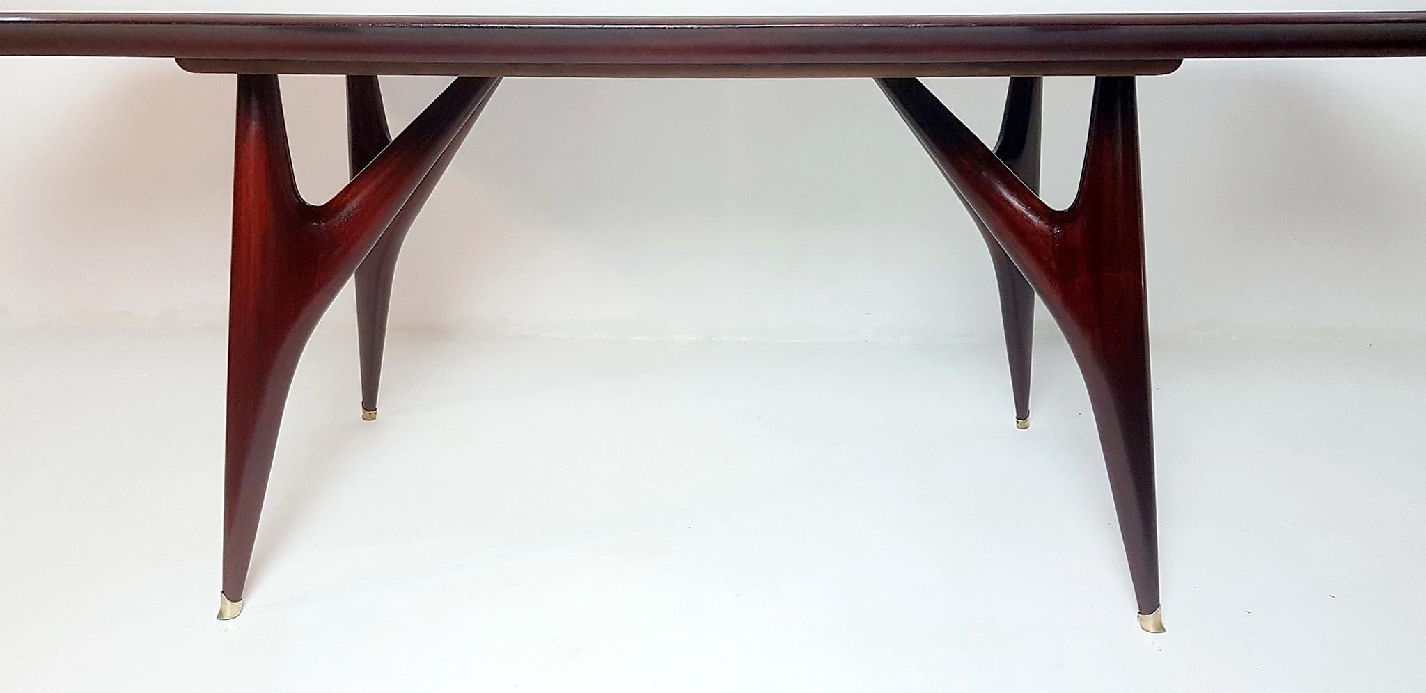 Fabulous large professionally restored dining table produced in Italy in the 1950s. The base is made in walnut and the legs has brass caps and finally the top which has an angular shape is made from glass which has a pale green/turquoise vivid