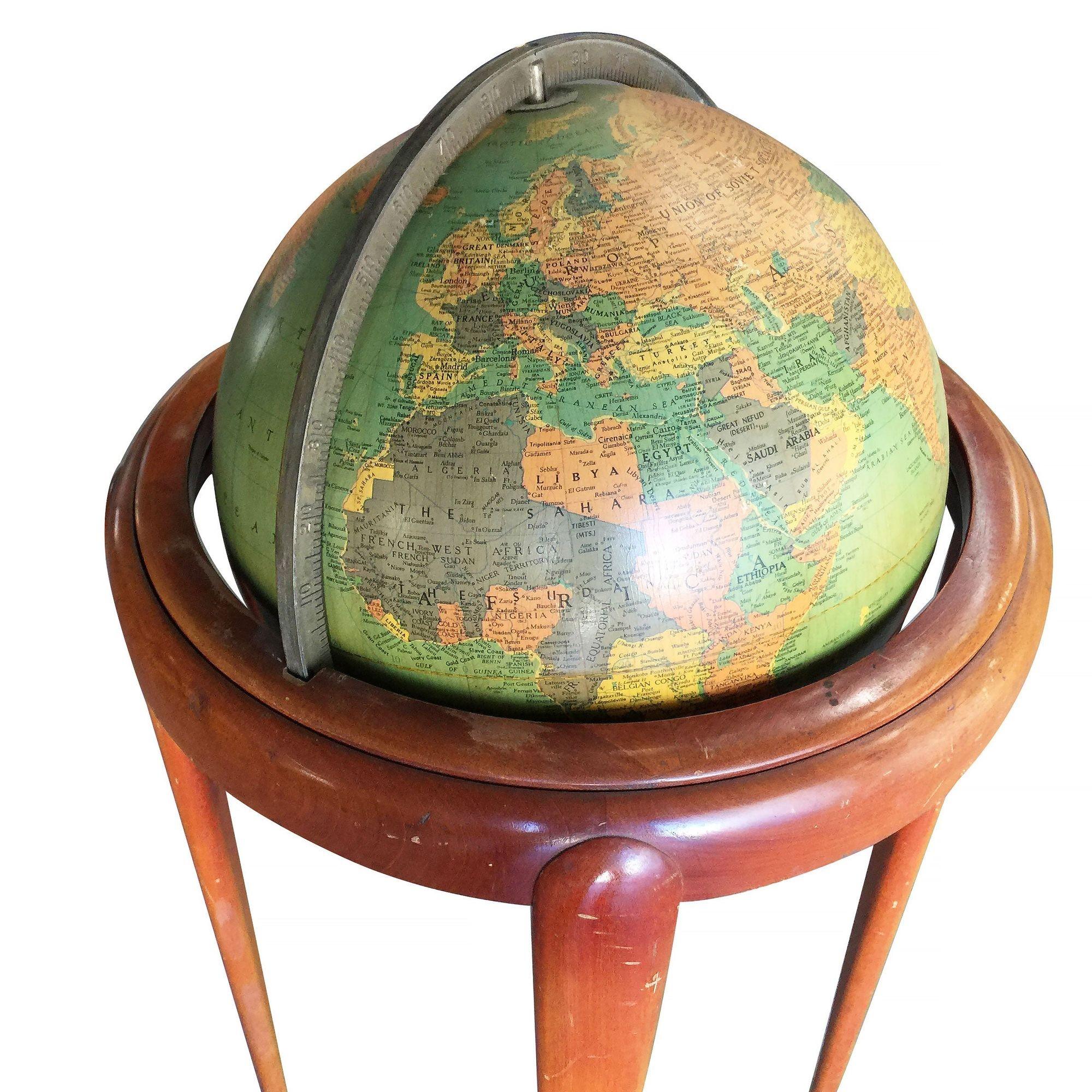 Mid-century era floor globe featuring a steel globe suspended by a mahogany stand. The globe rotates 360 degrees on two point axis comprised of metal ball bearings.

Manufactured by Replogle.