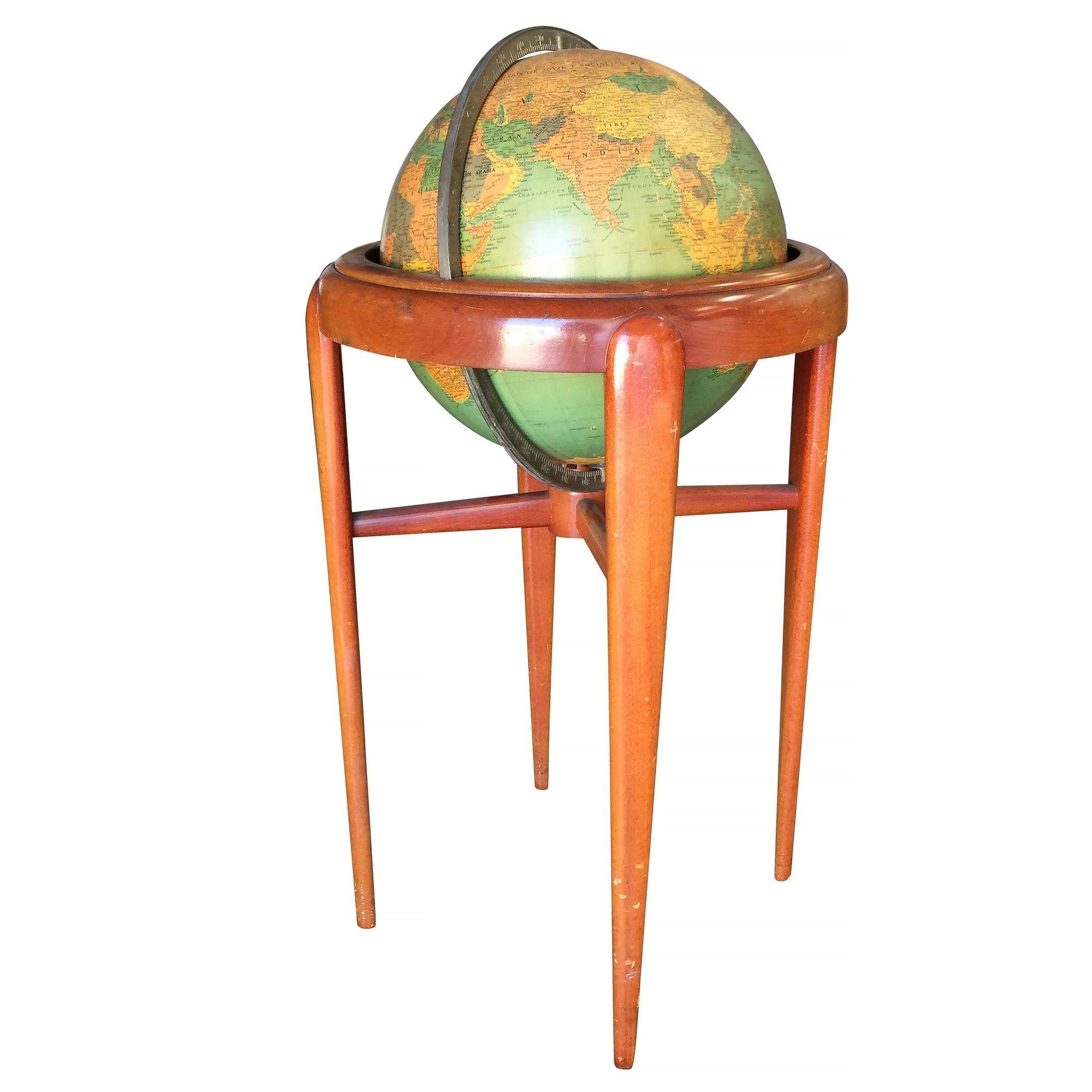 Mid-century era floor globe featuring a steel globe suspended by a mahogany stand. The globe rotates 360 degrees on two point axis comprised of metal ball bearings.

Manufactured by Replogle.