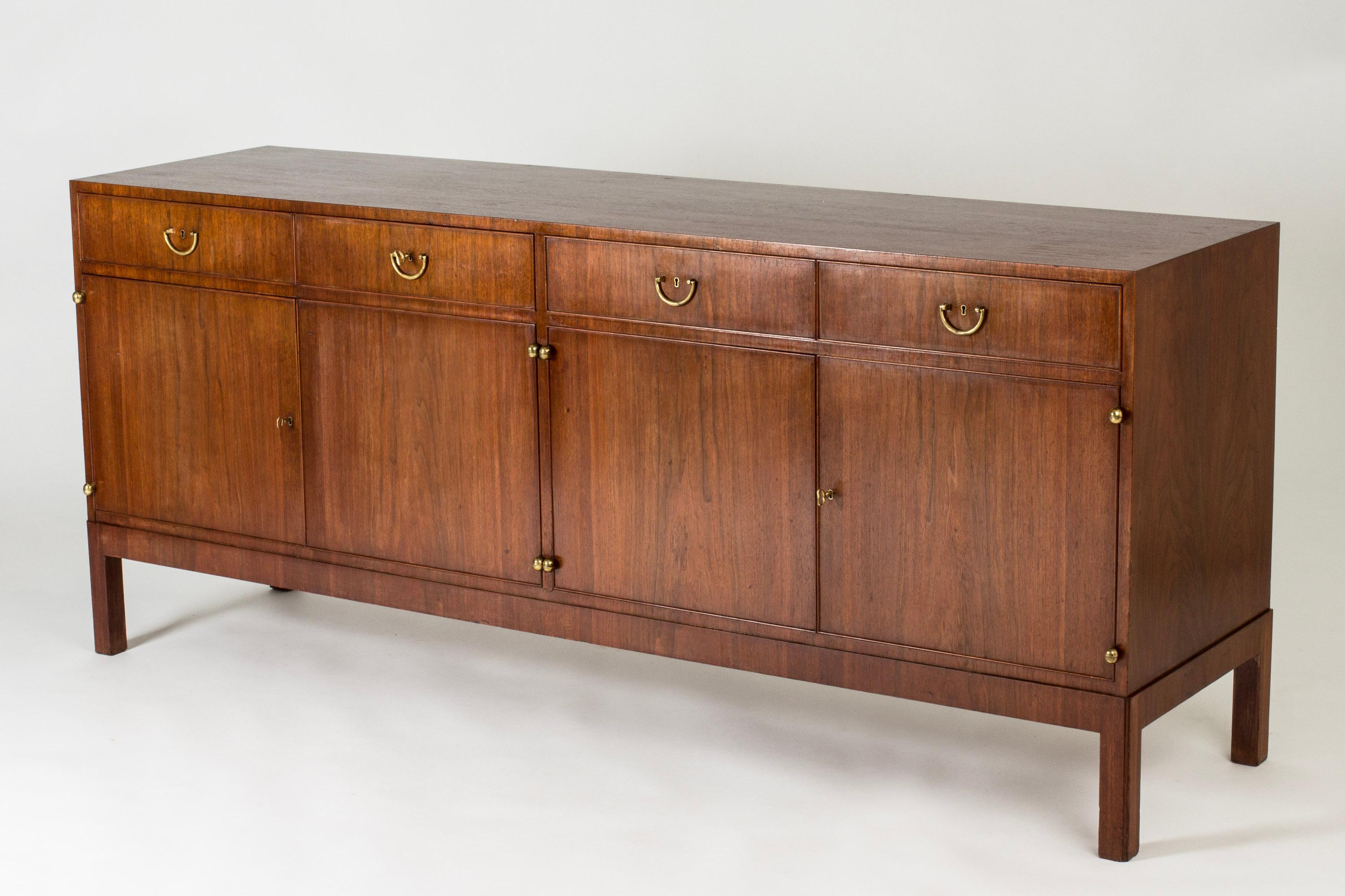 Elegant mahogany sideboard by Josef Frank, in a rare large size. Decorative brass details.