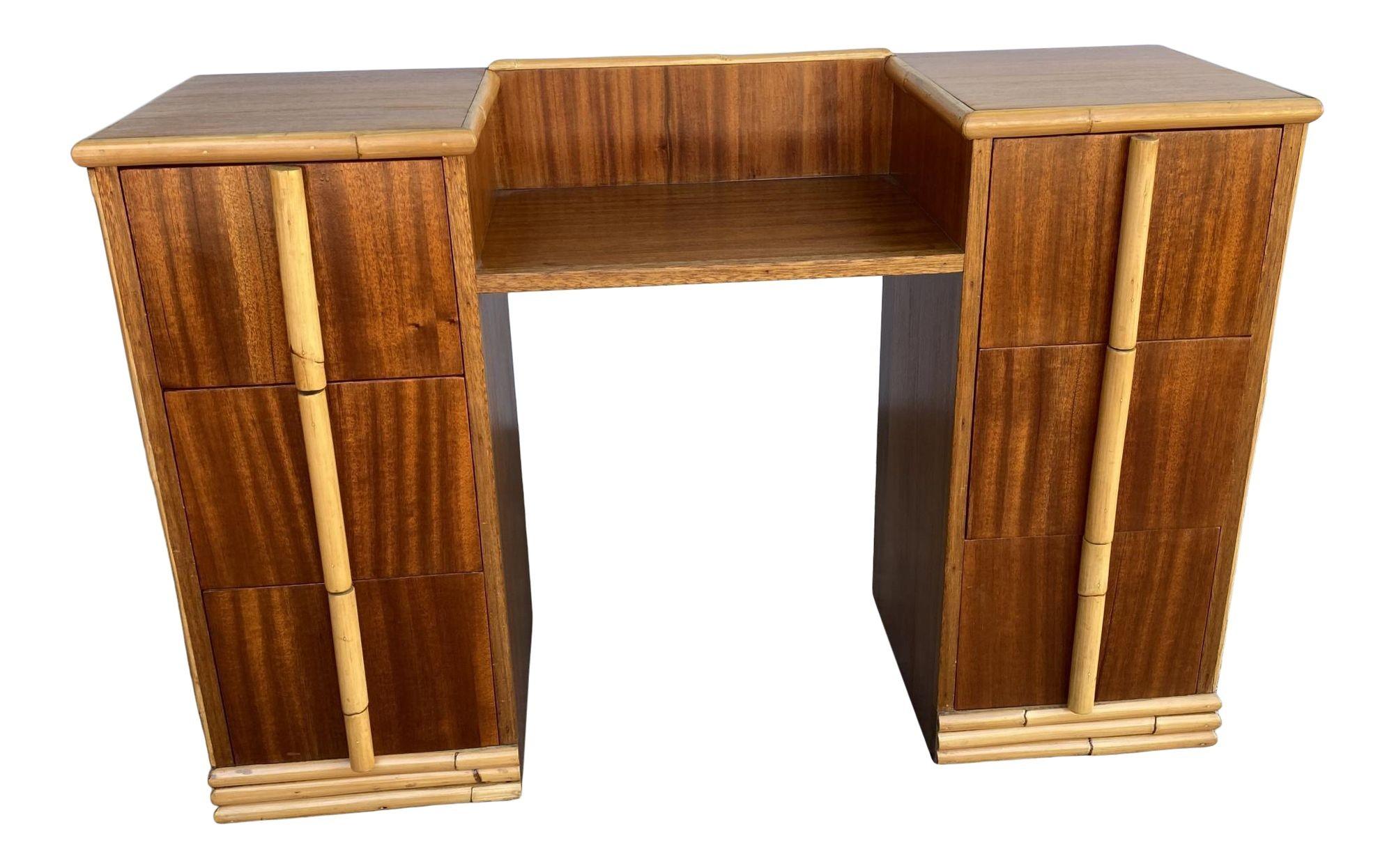 Original 1940s midcentury mahogany vanity with rattan accents. The vanity features an extensive rattan trim along the mahogany surface and custom made rattan pulls.

Restored to new for you.

All rattan, bamboo, and wicker furniture has been