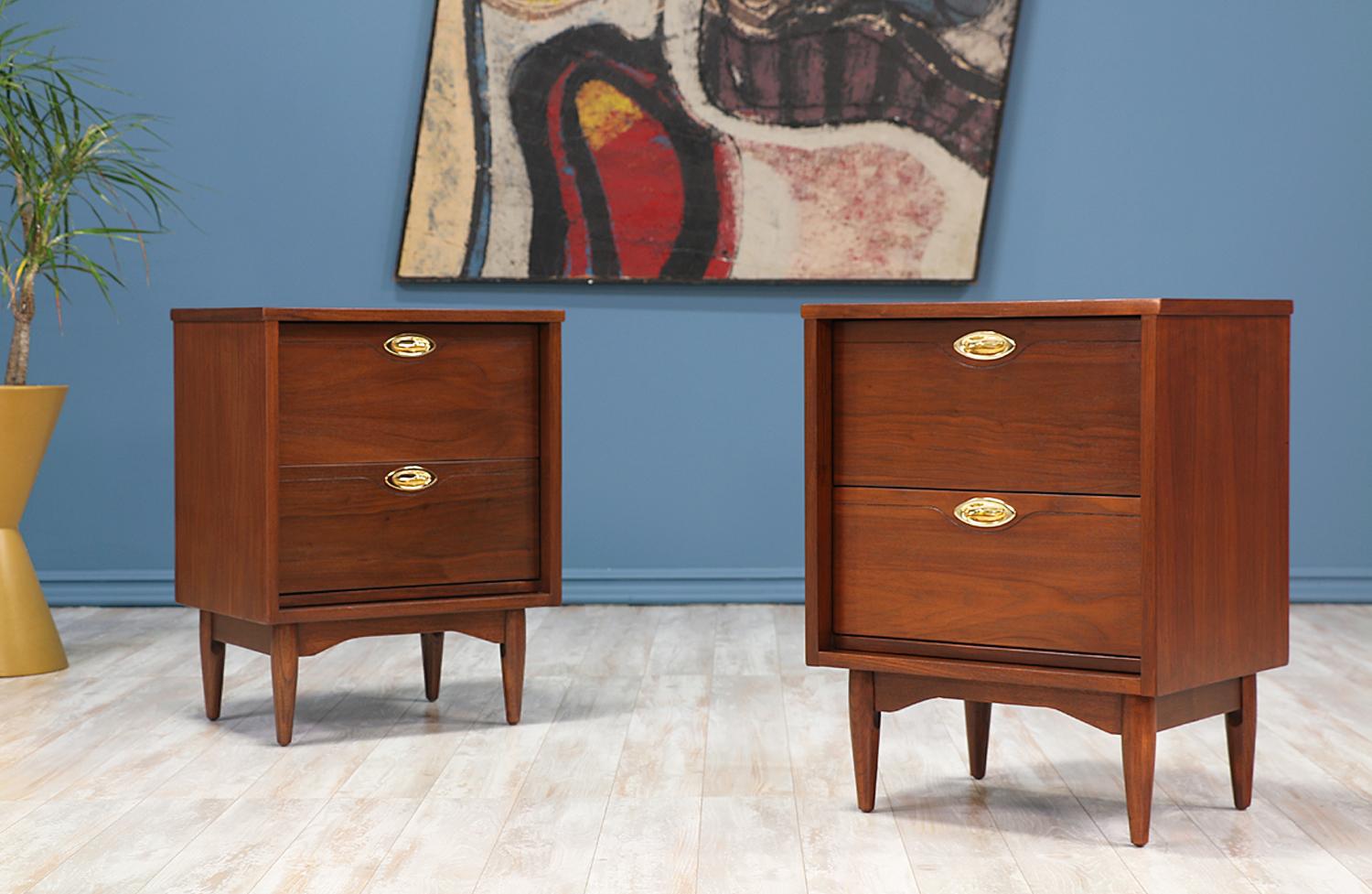 Pair of Mid-Century Modern nightstands manufactured by Hooker in the United States, circa 1960s. Crafted for Hooker’s “Mainline” collection, these nightstands feature a solid walnut wood base and a casing featuring two dovetailed drawers adorned