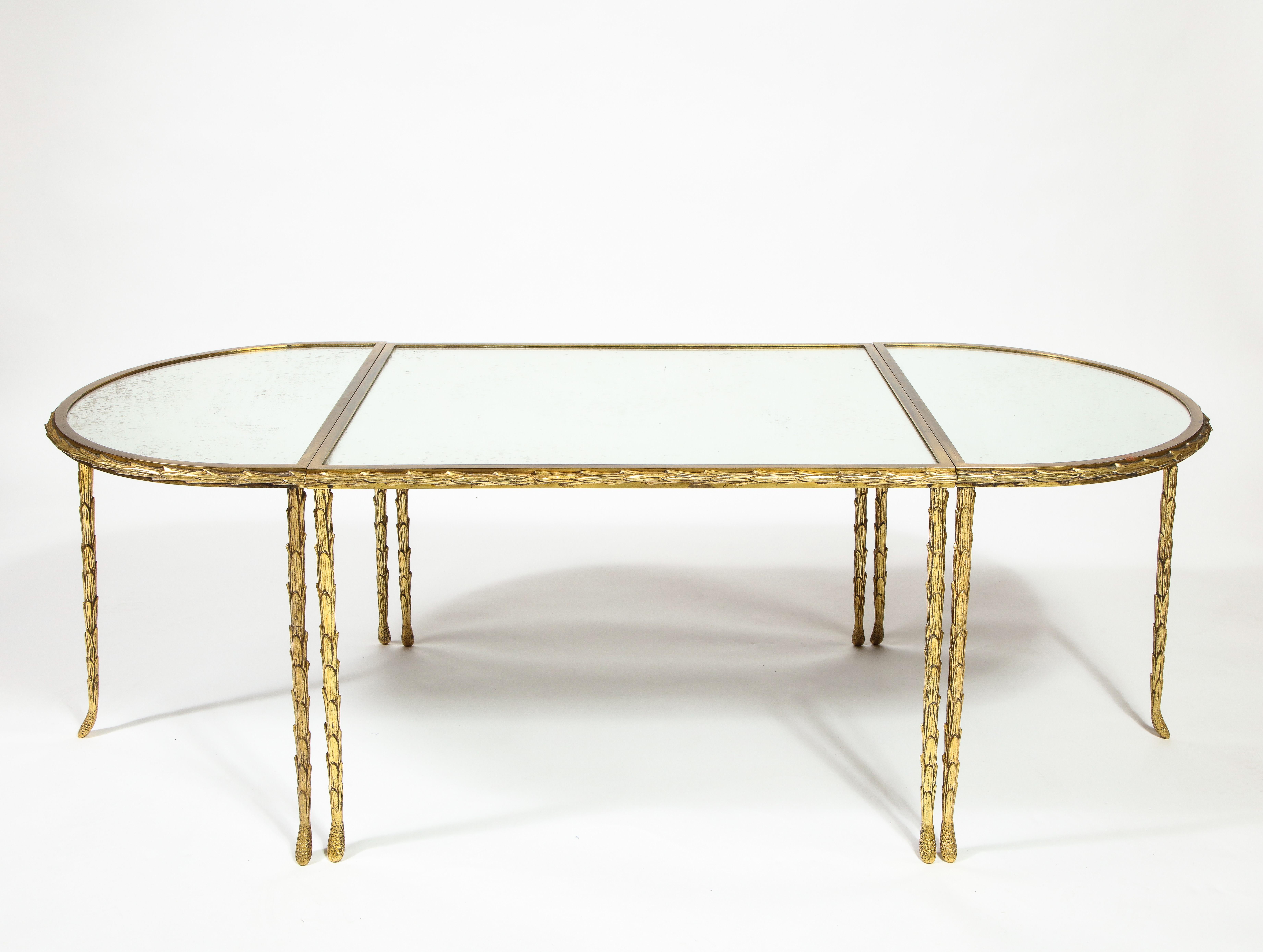 This modular oval form coffee table was created in  French design house Maison Baguès during the mid-20th century. Known for their decorative lighting and metalwork, Maison Baguès specialized in gilt bronze furnishings with a focus on organic motifs