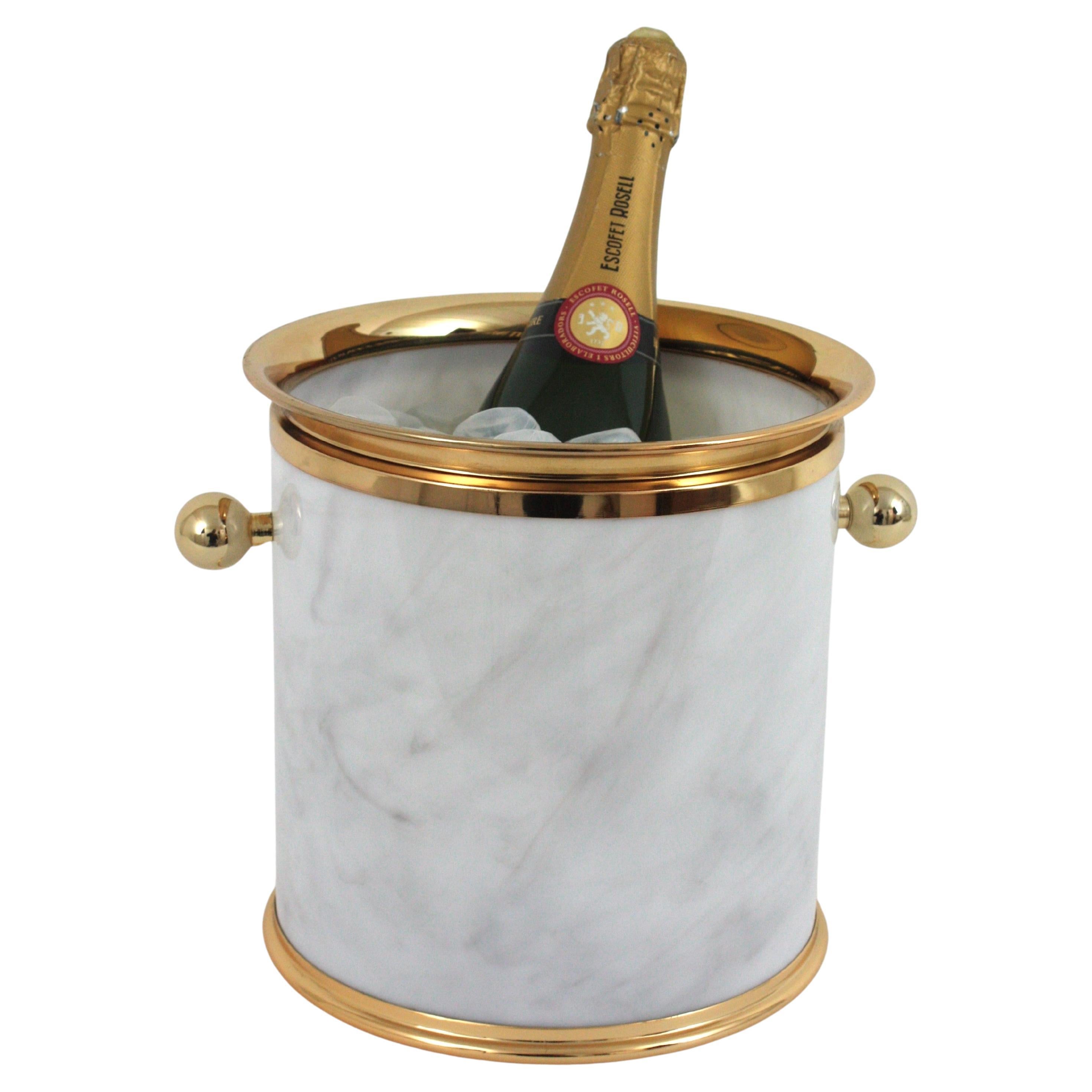 Eye-catching Mid-Century Modern marbled lucite ice bucket with brass handles. Italy, 1960s.
This ice bucket is comprised by a white acrylic cylindrical container with faux marble design, ball handles in brass at both sides and brass rims.
This sexy