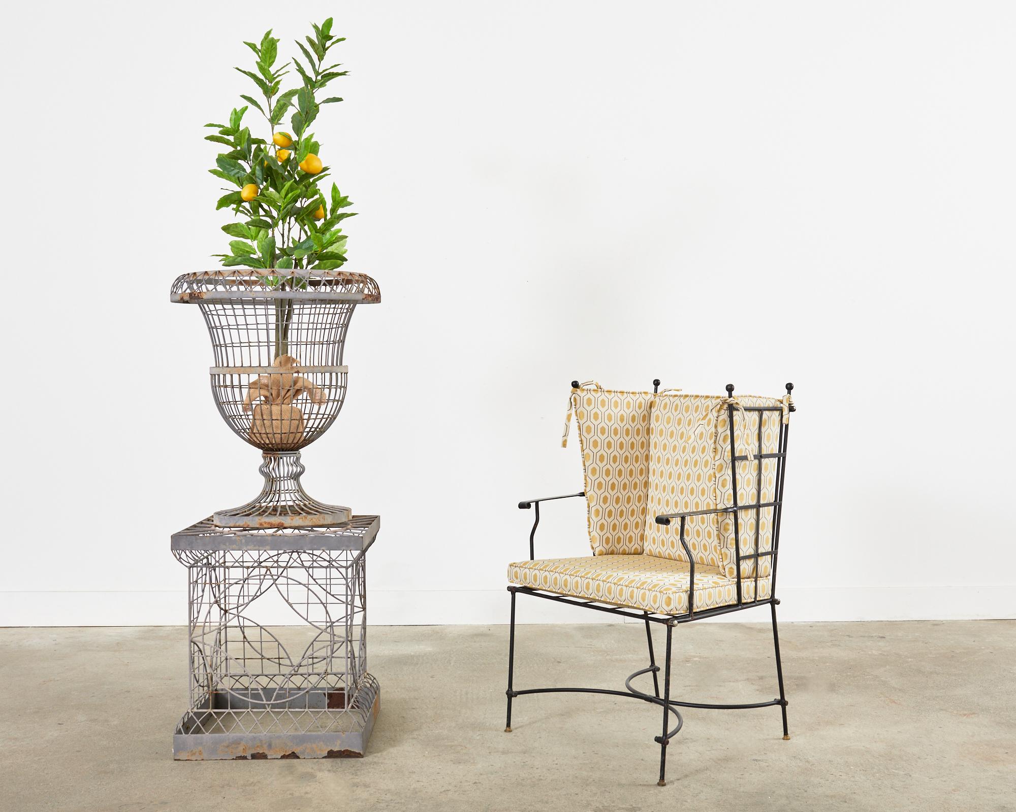 Whimsical Mid-Century Modern patio and garden wingback armchair made in the manner and style of Mario Papperzini for John Salterini. The armchair features a wrought iron frame with a lattice seat, back, and wings ending with ball finials. The