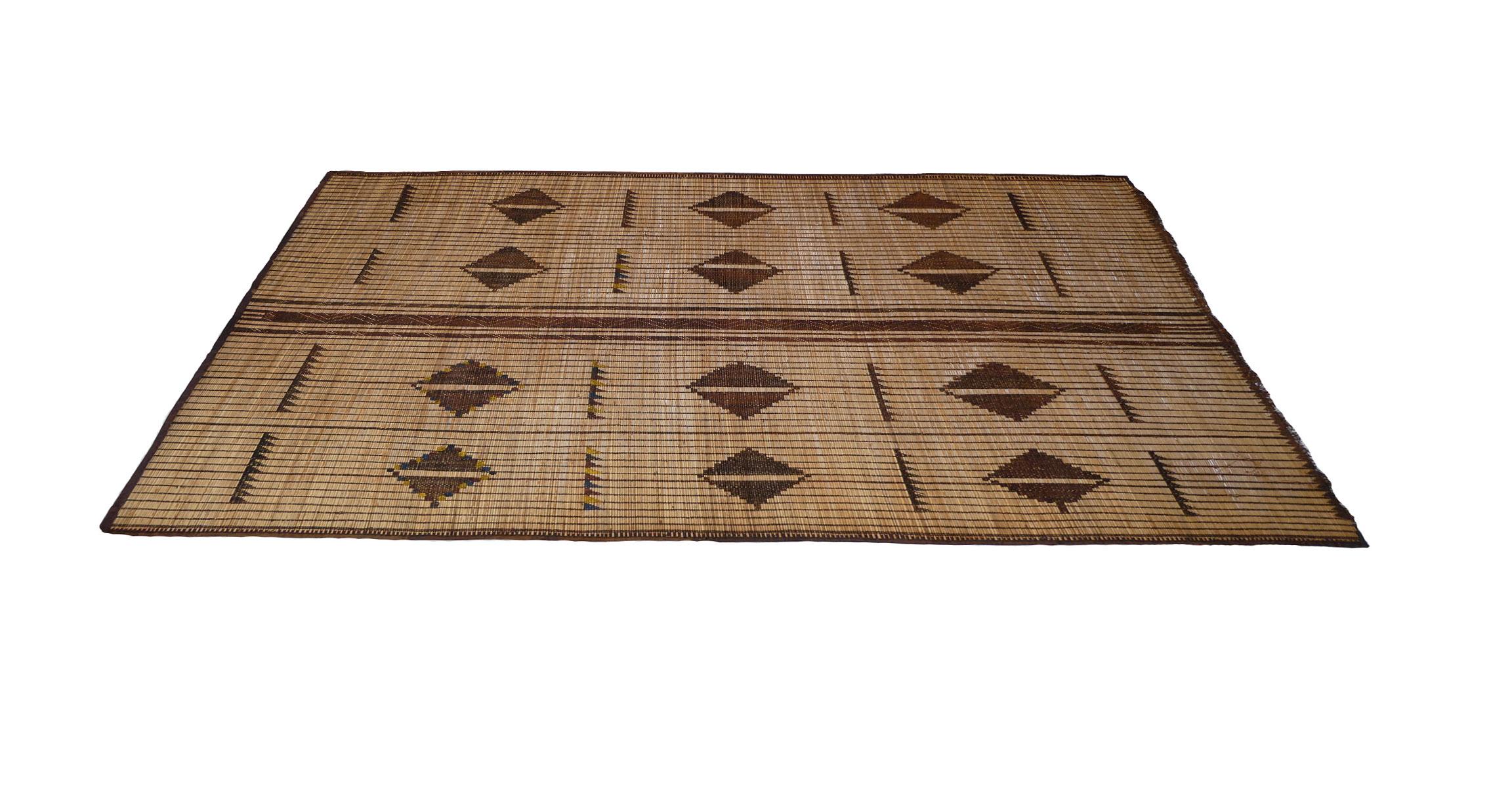 Natte touareg mauritanienne du milieu du siècle, tissée à la main avec des roseaux de palmier. Cuir véritable teint végétal bleu indigo et jaune dans un design tribal avec des symboles berbères fascinants.
Dimensions : 6'2 x 9' 