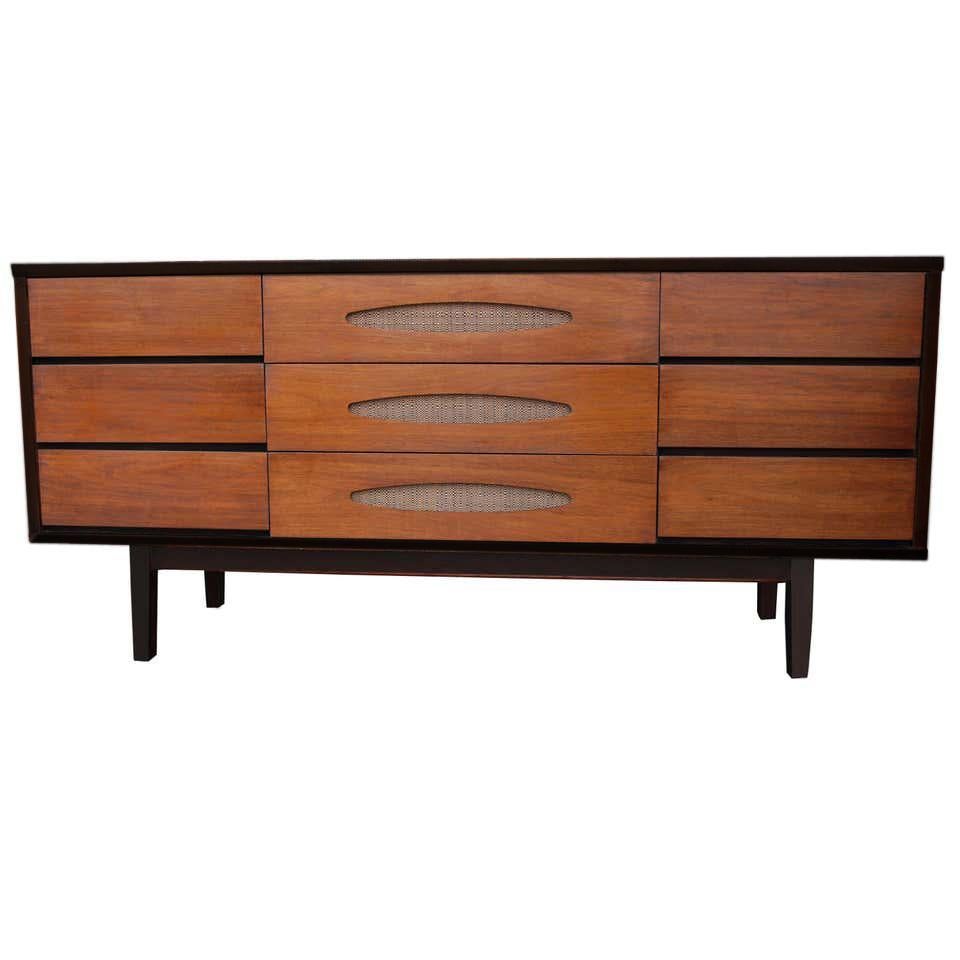The Real McCoy 9 drawer dresser in walnut. Restored with ebonized case and base. 
 Horizontal drawer under-pulls with geometric detail highlighted with grass cloth inserts.

See matching nightstands available.

 